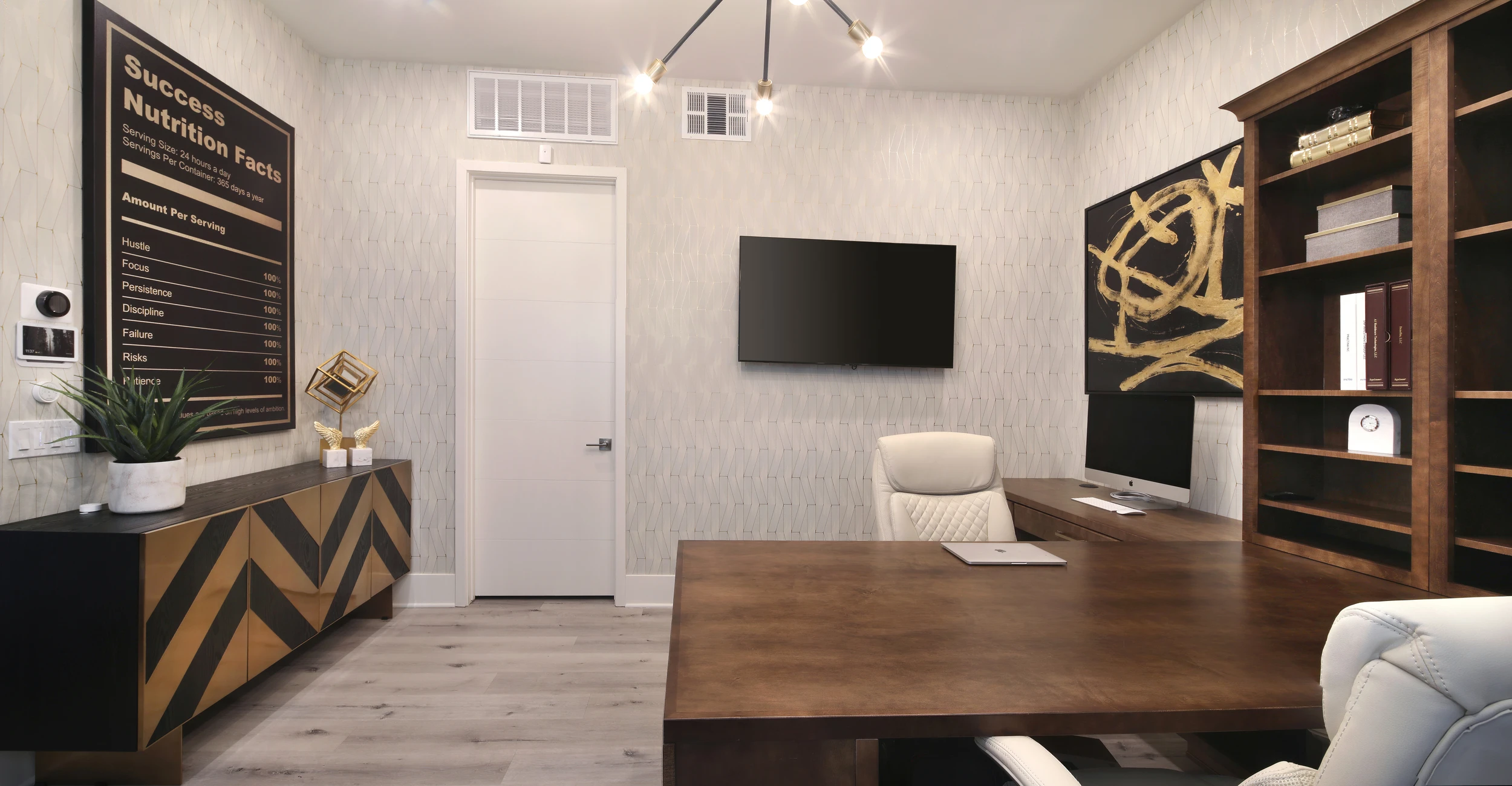 Home office with dark shelving, patterned rug, and chevron console