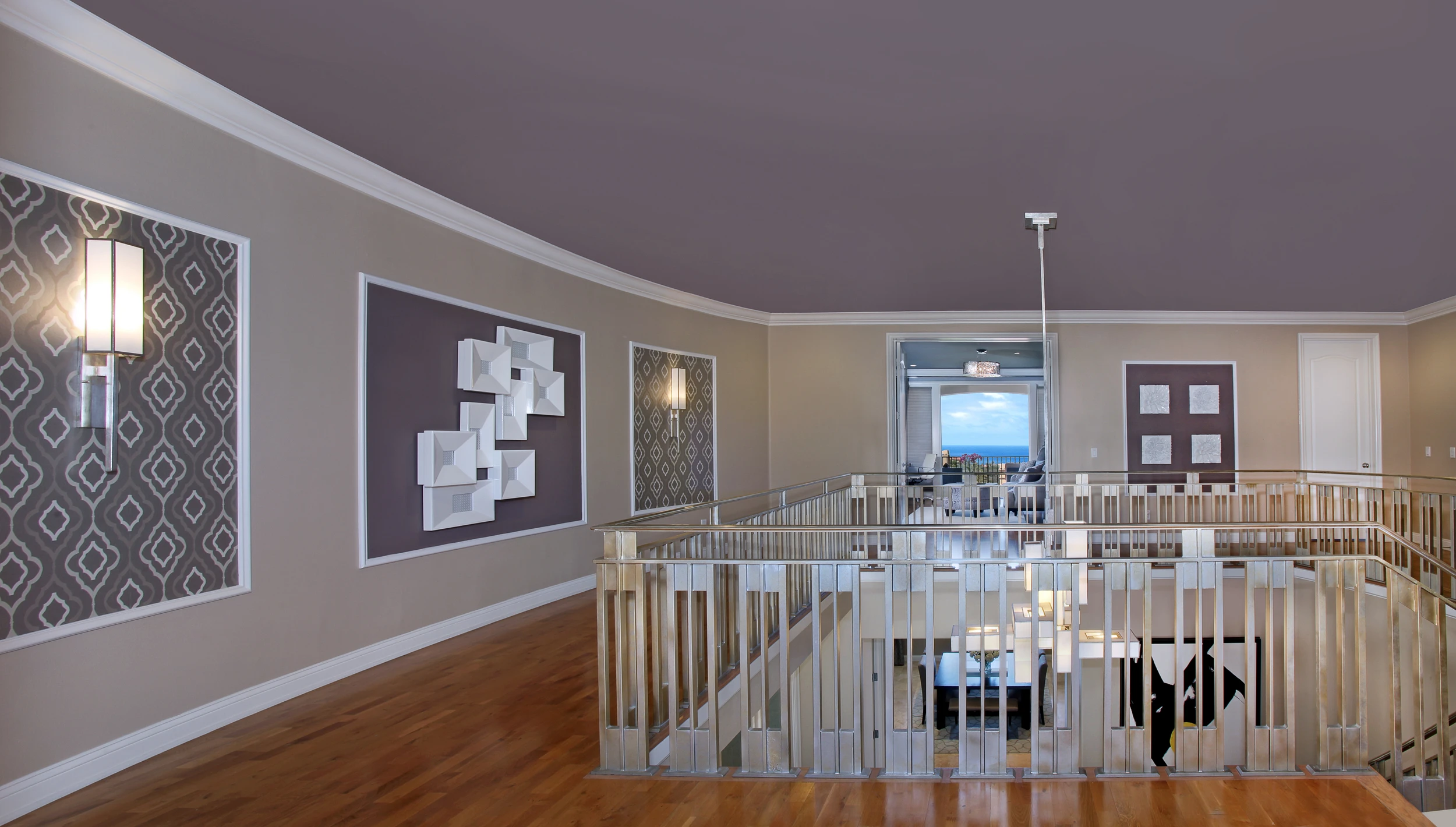 Upper landing with white railings, dark patterned walls, and pendant lights