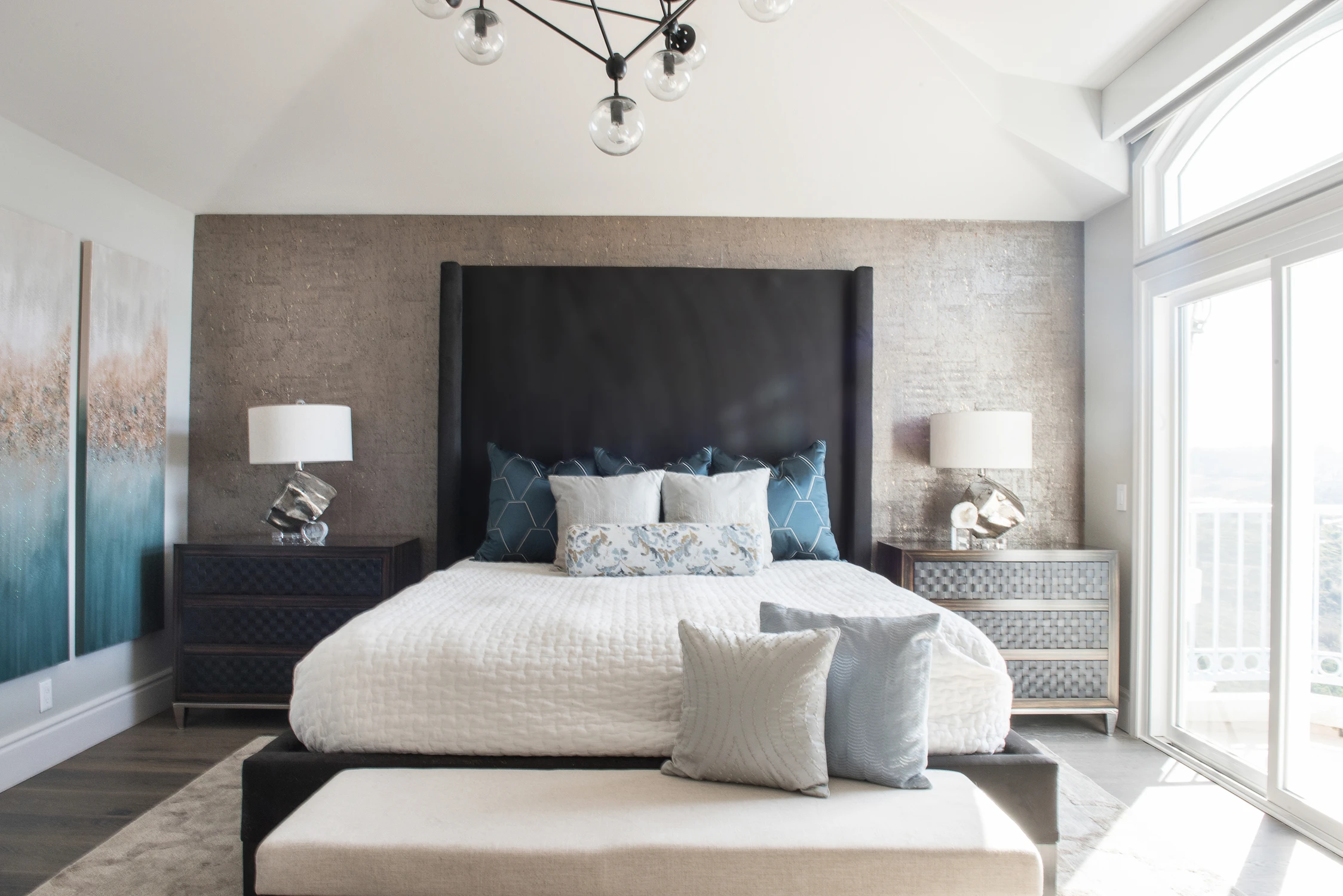 Bedroom with a wide upholstered headboard and blue pillows
