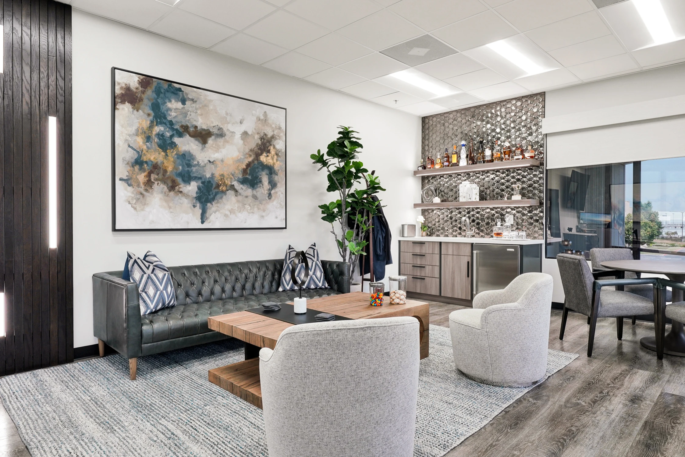 Office lounge with tufted sofa, coffee table, and beverage bar