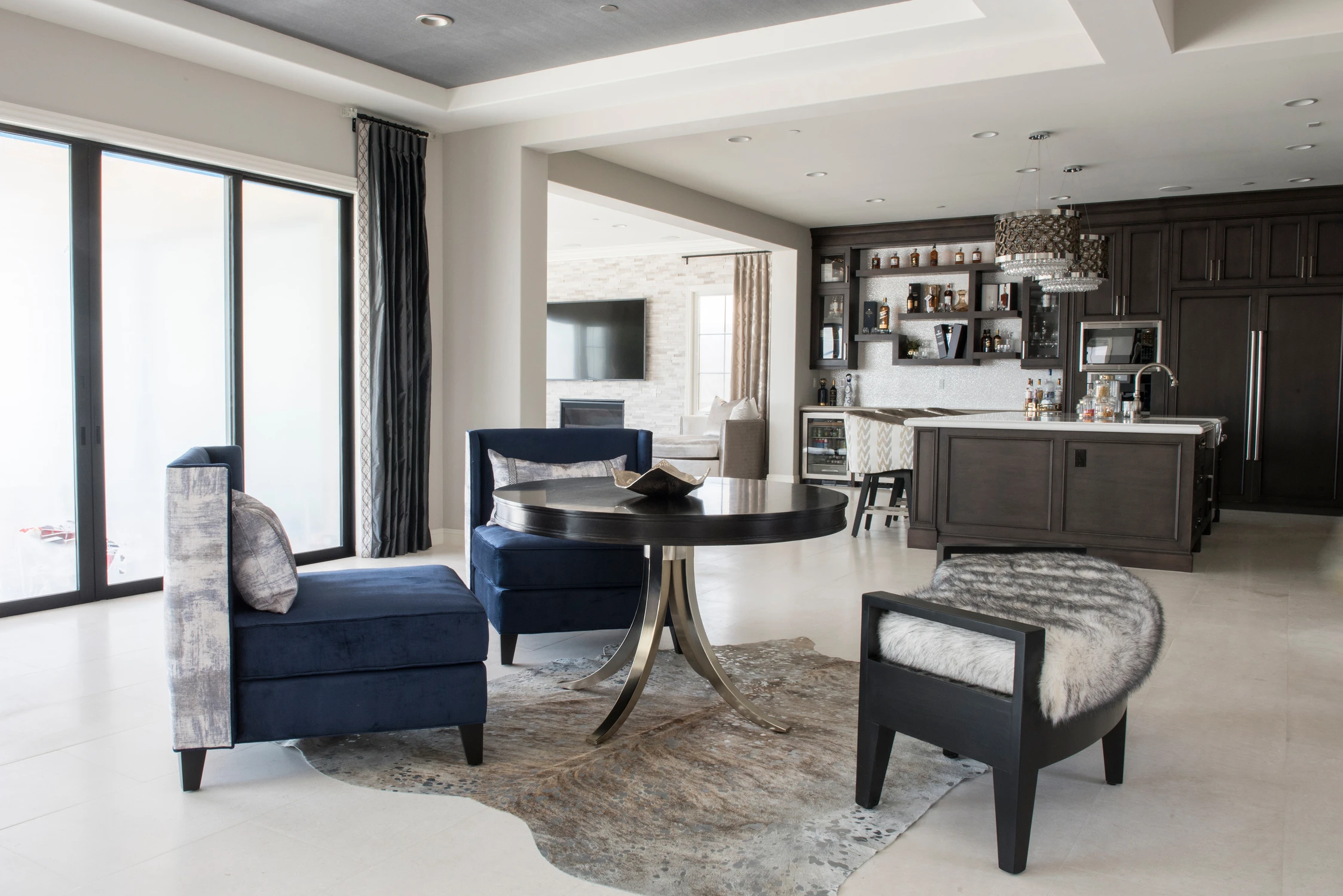 Sitting area with navy armchairs beside a dark built-in bar