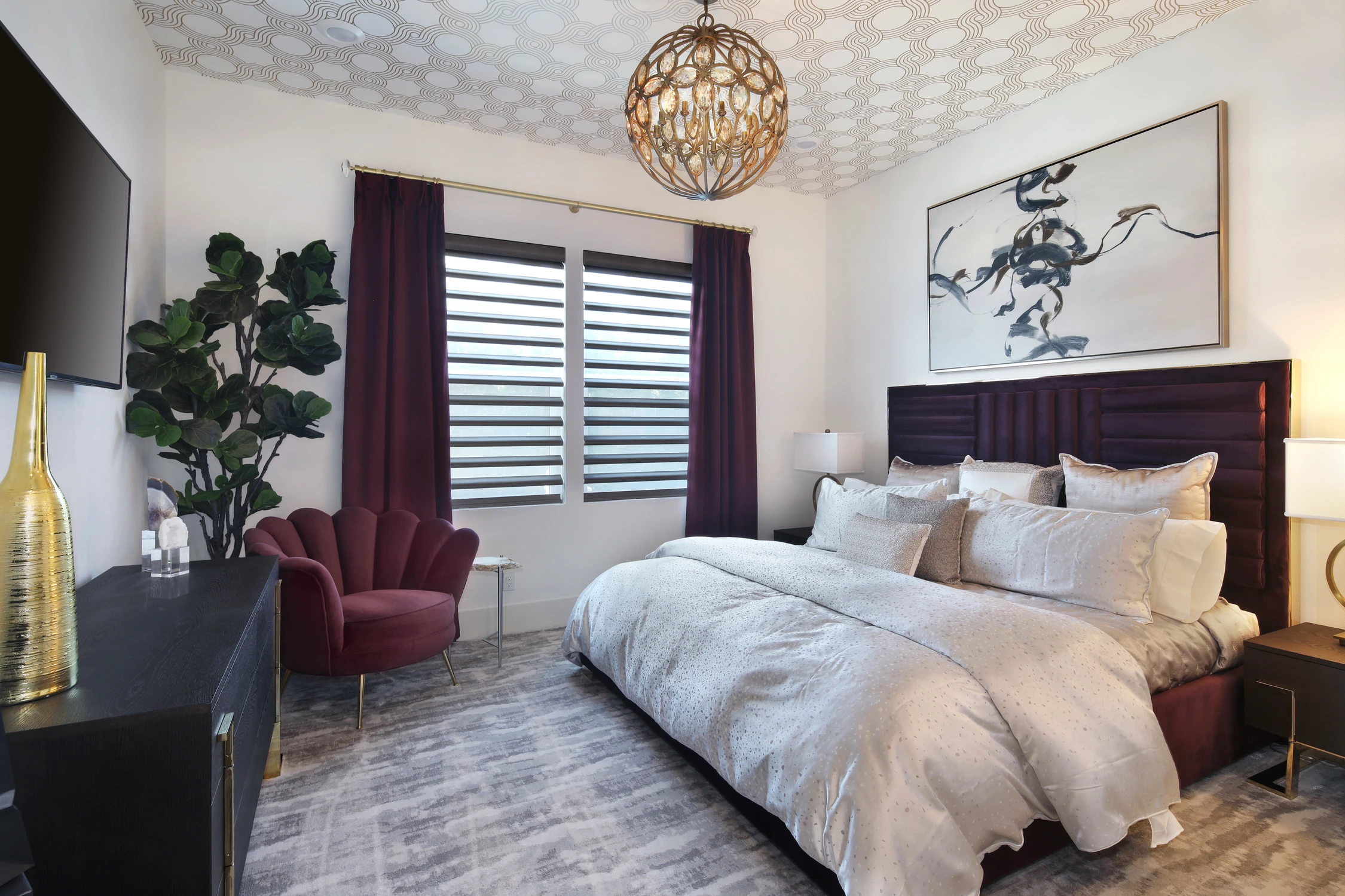 Bedroom with purple accent chair and plum drapery