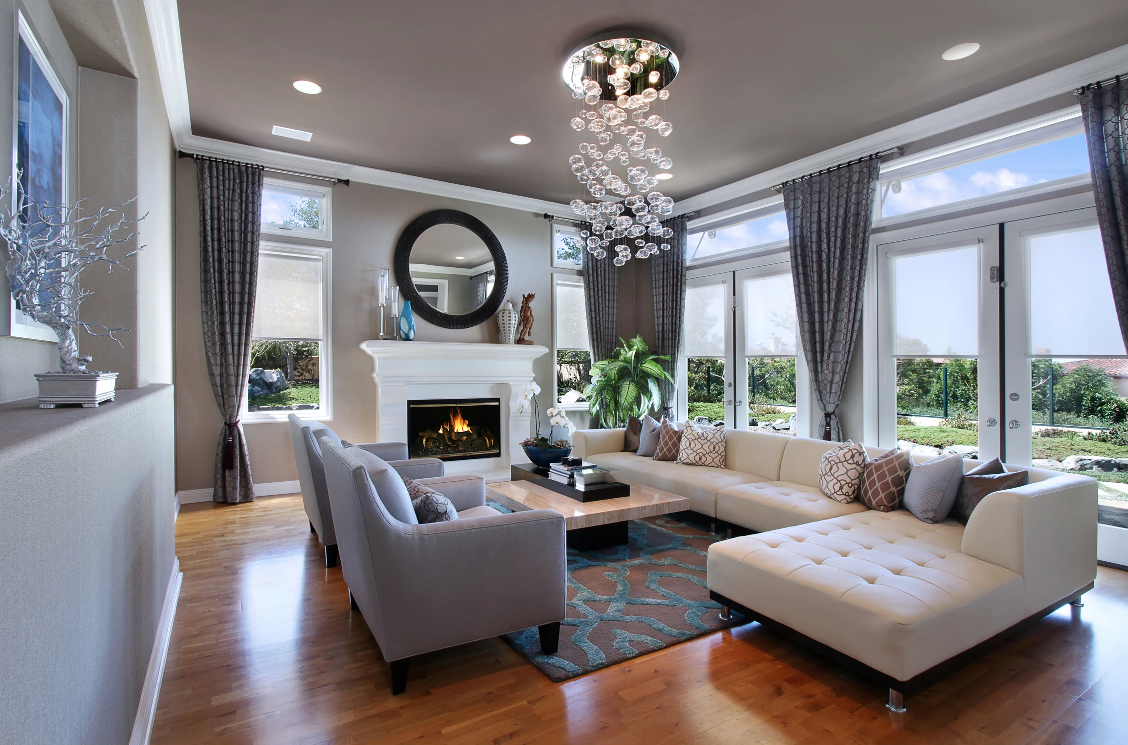 Living room with white sectional, fireplace, and wide window view