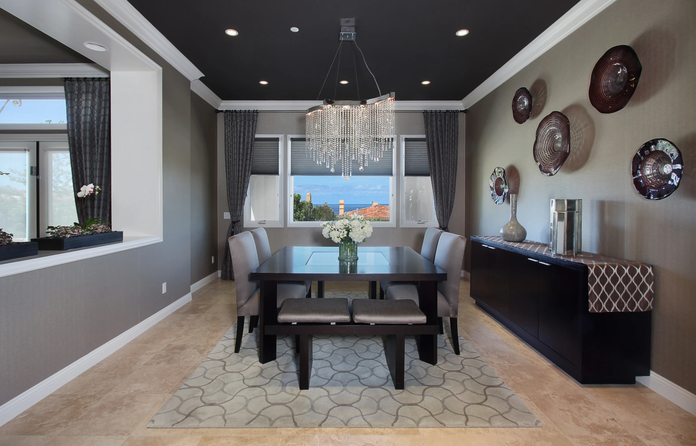 Dining room with dark walls, wood table, and view toward the ocean
