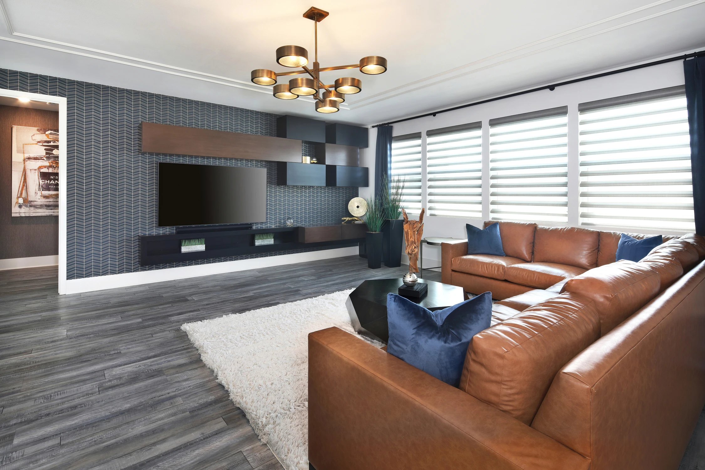 Media room with sectional seating and dark tiled television wall