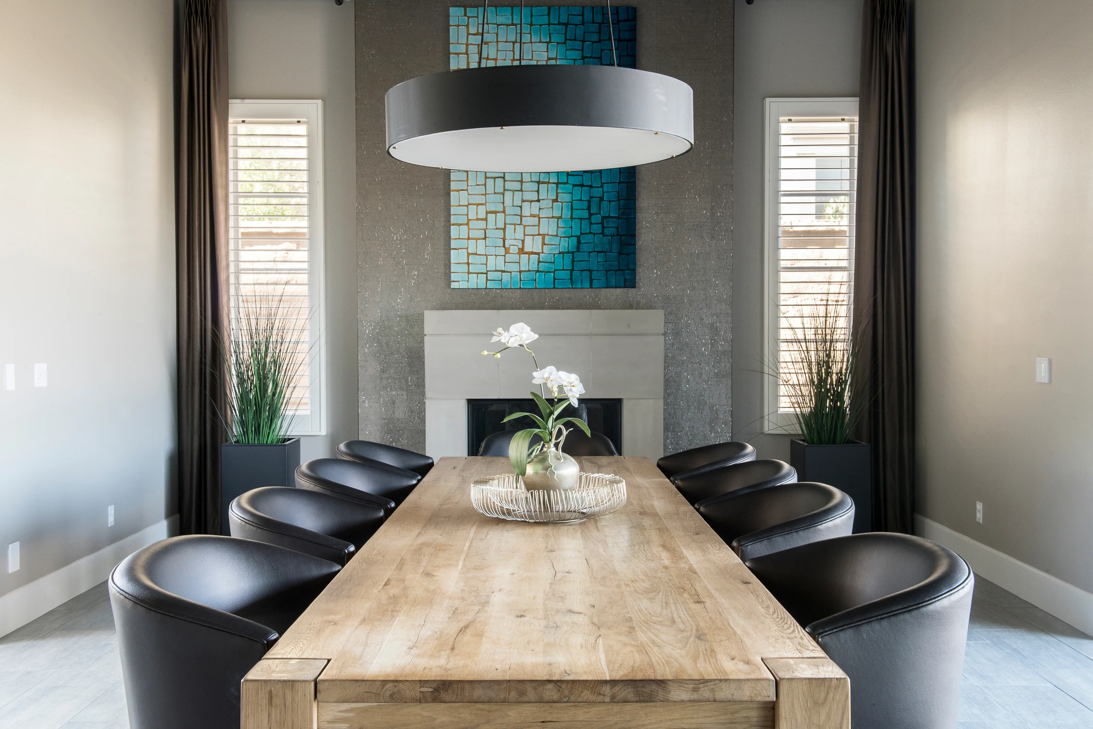 Dining room with wood table, black chairs, and blue tile artwork