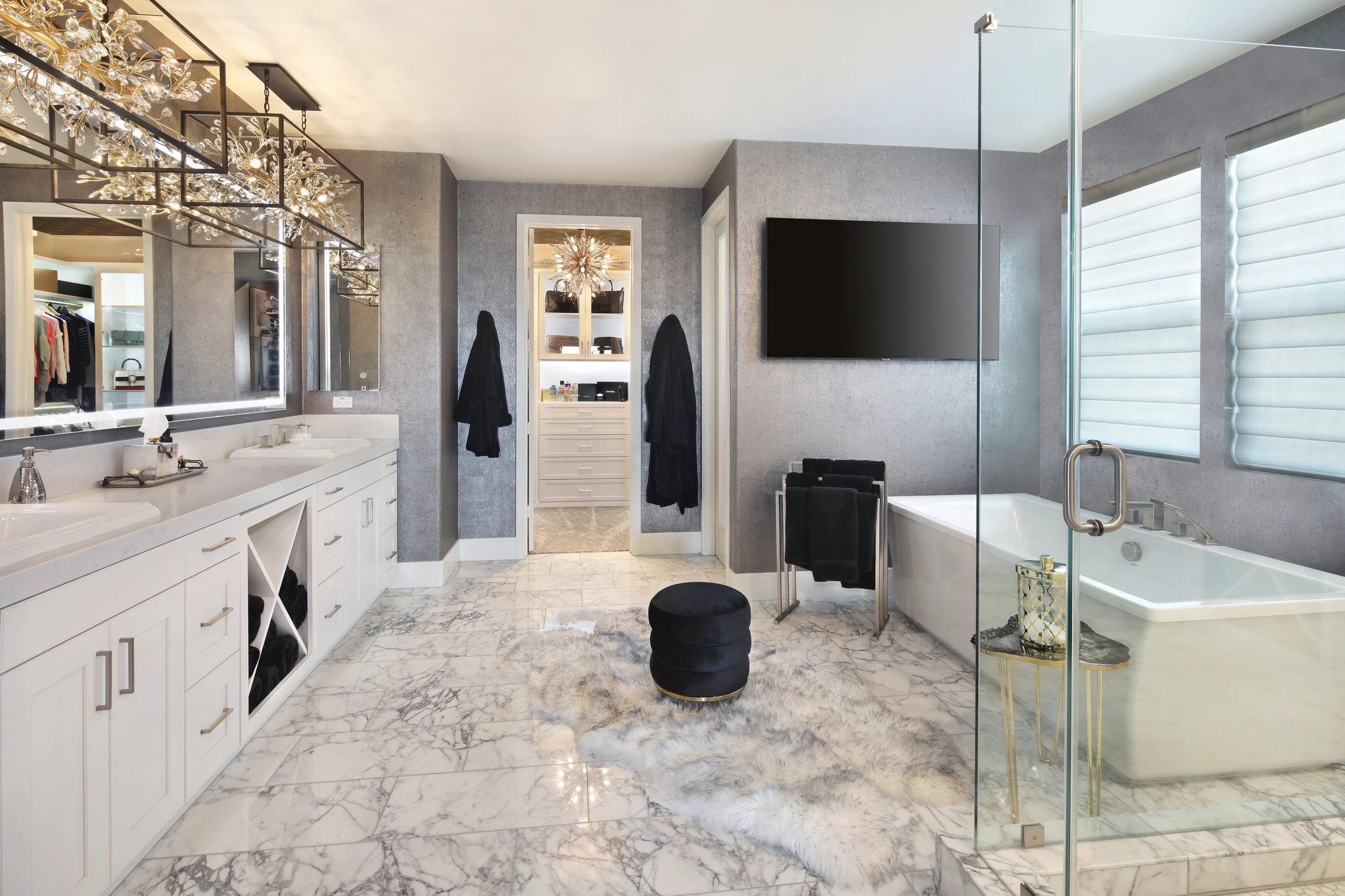 Master bathroom with white vanity, marble floor, and glass shower