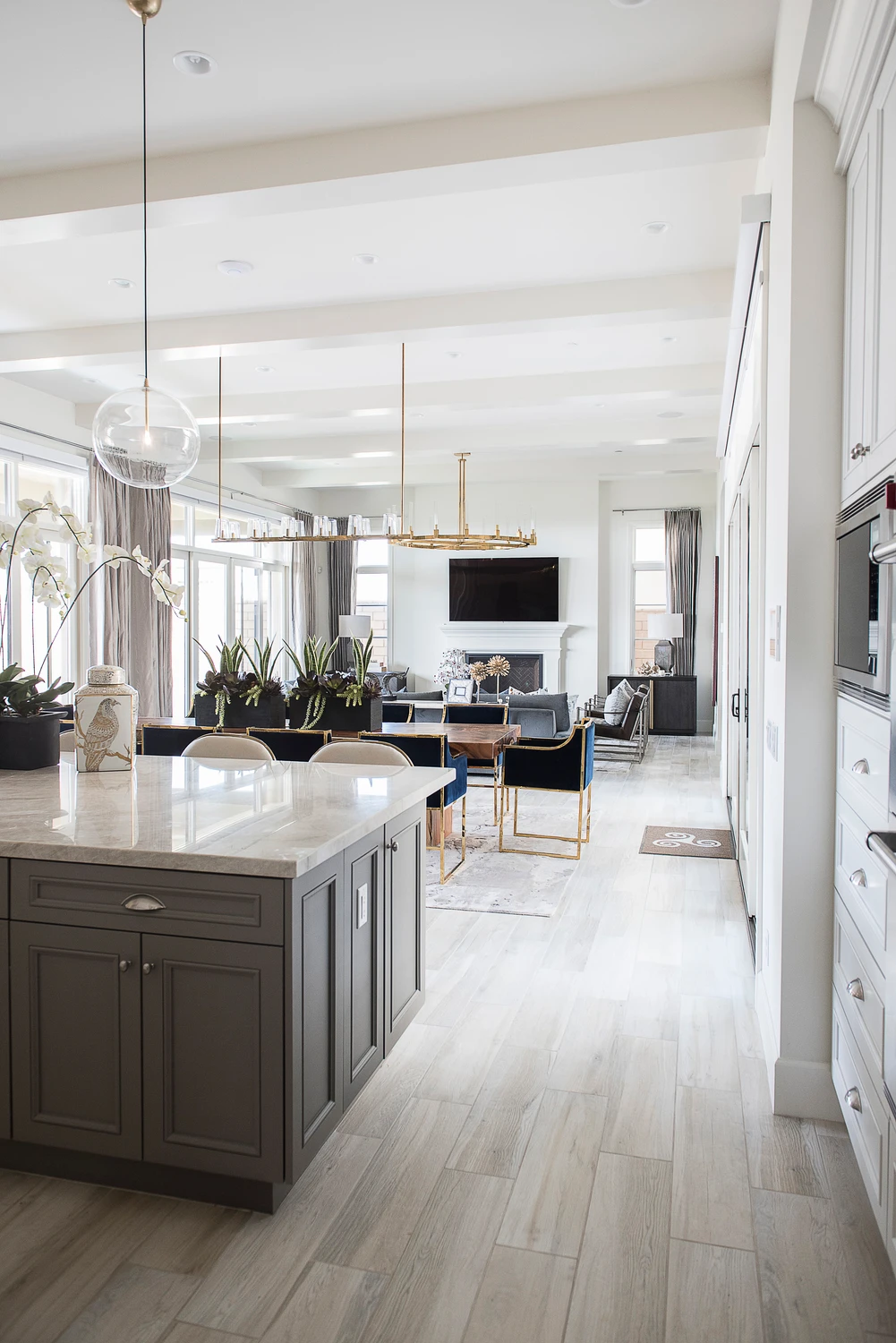 Open kitchen with gray island and view toward living and dining areas