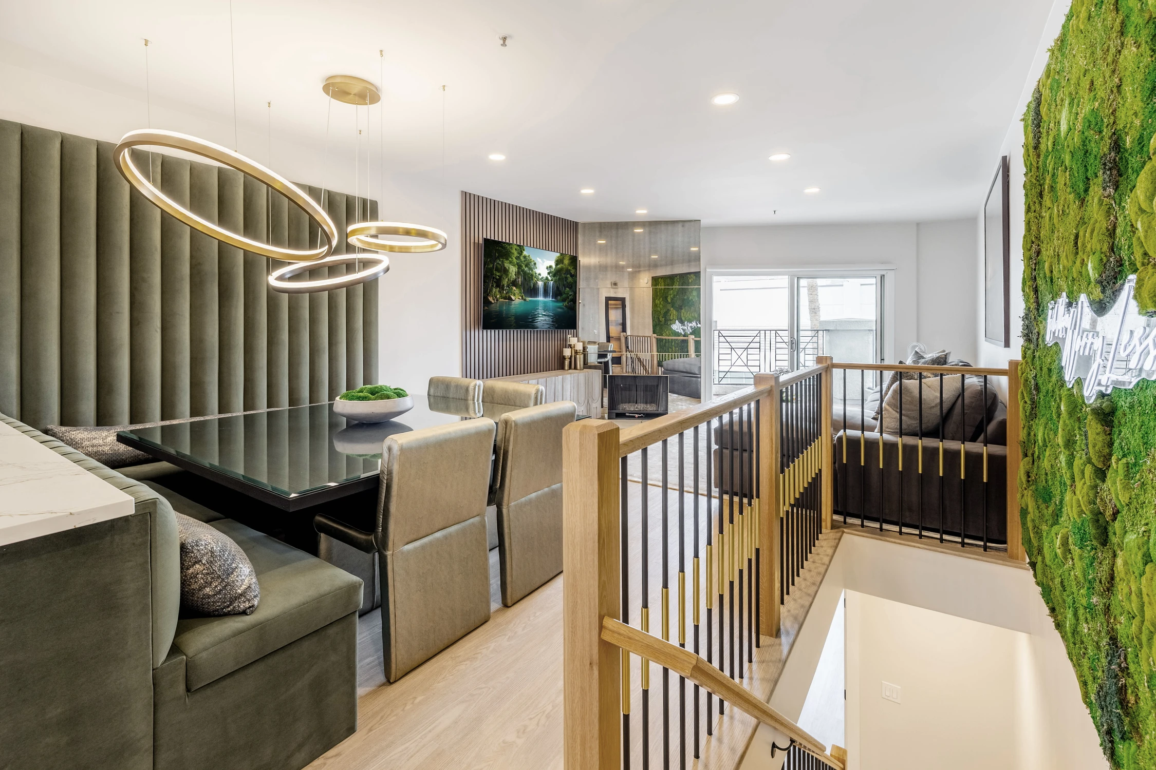 Open living area with moss wall, black slats, and gold railing