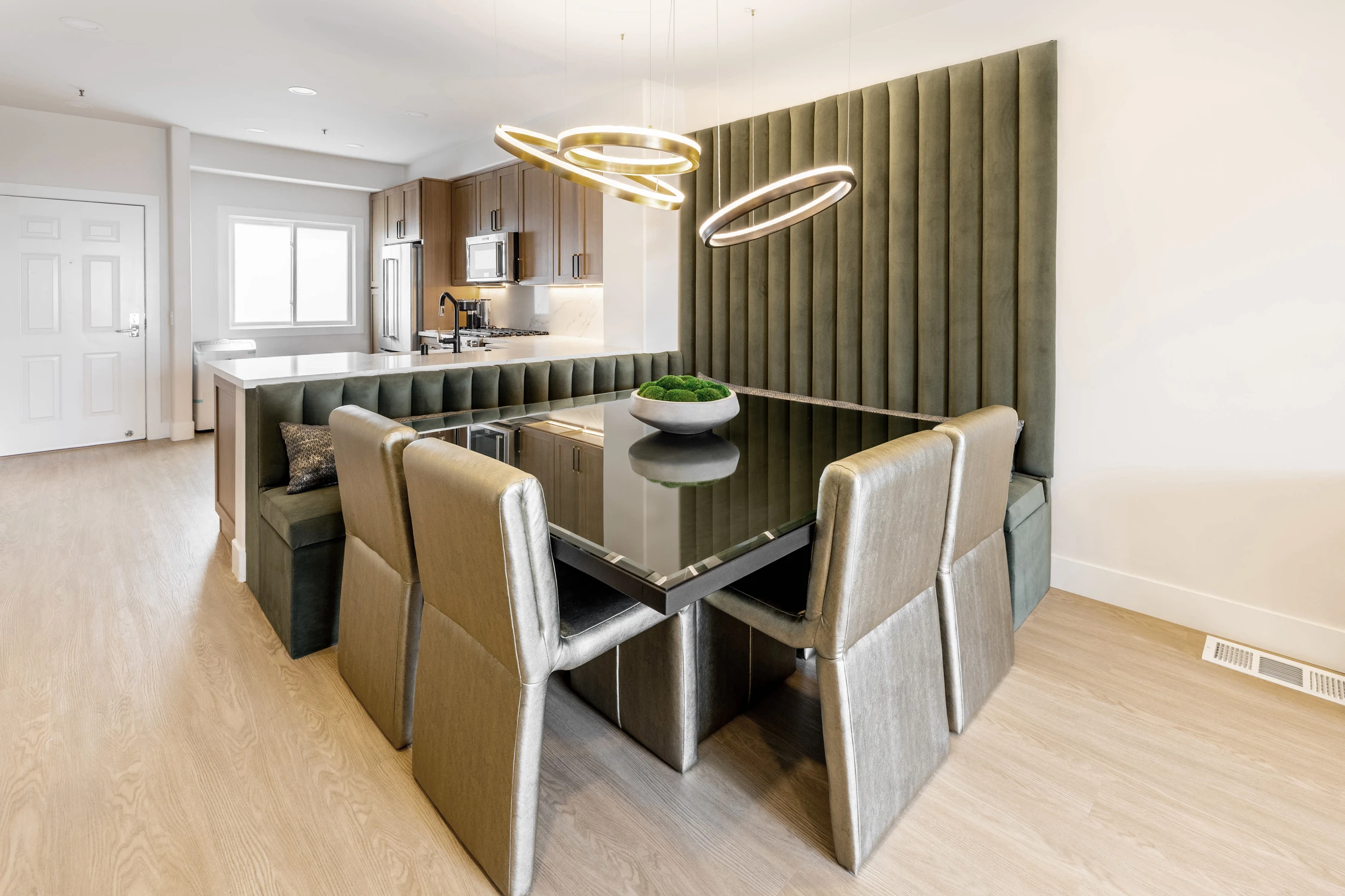 Living room facing dining area with green banquette seating