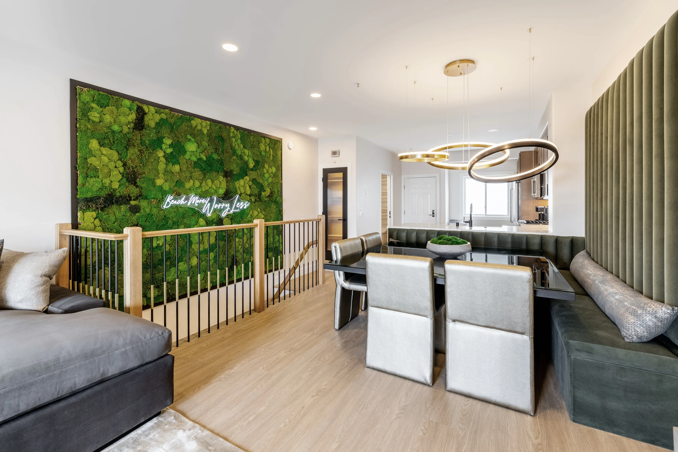 Open living and dining space with moss wall and sculptural lights