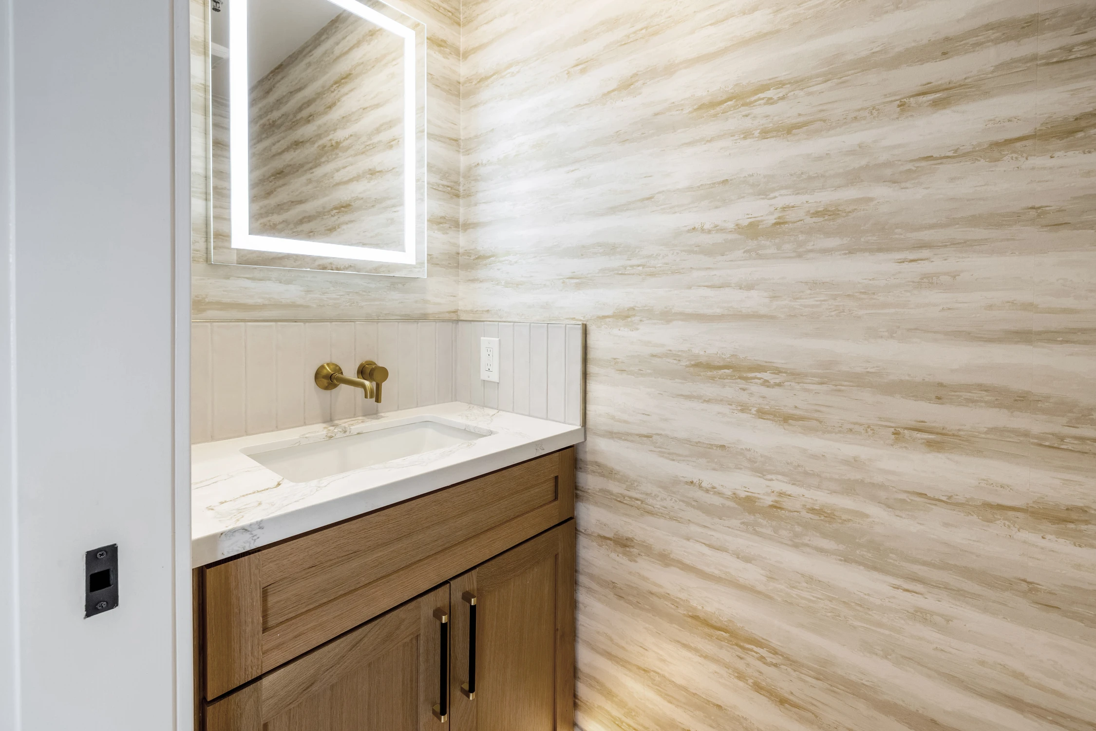 Powder room vanity with wood cabinet and wavy tile wall