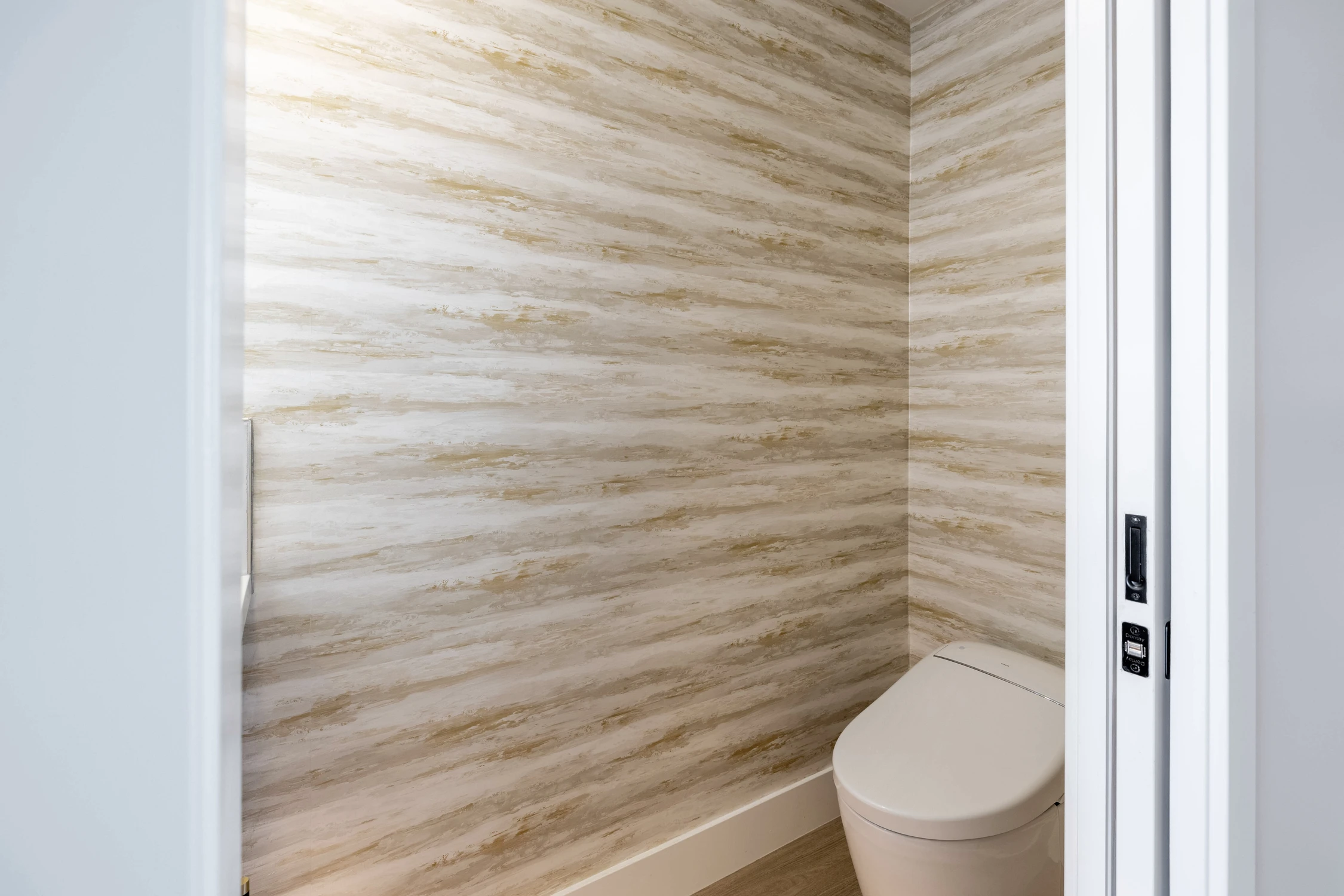Powder room with textured wall tile and white toilet