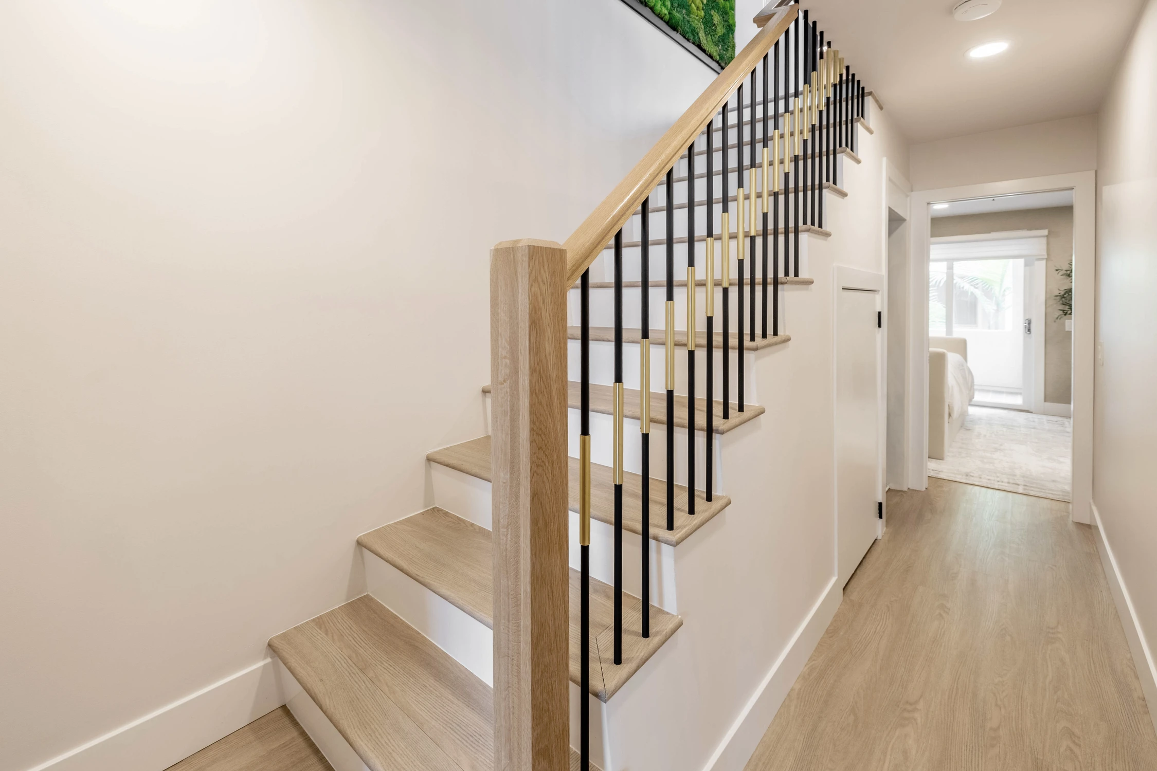 Staircase with black railing and light wood handrail