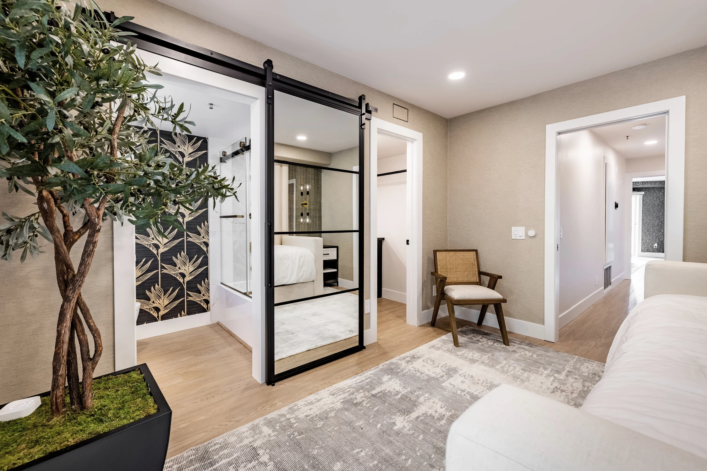Bedroom entry with black floral mural and white bench