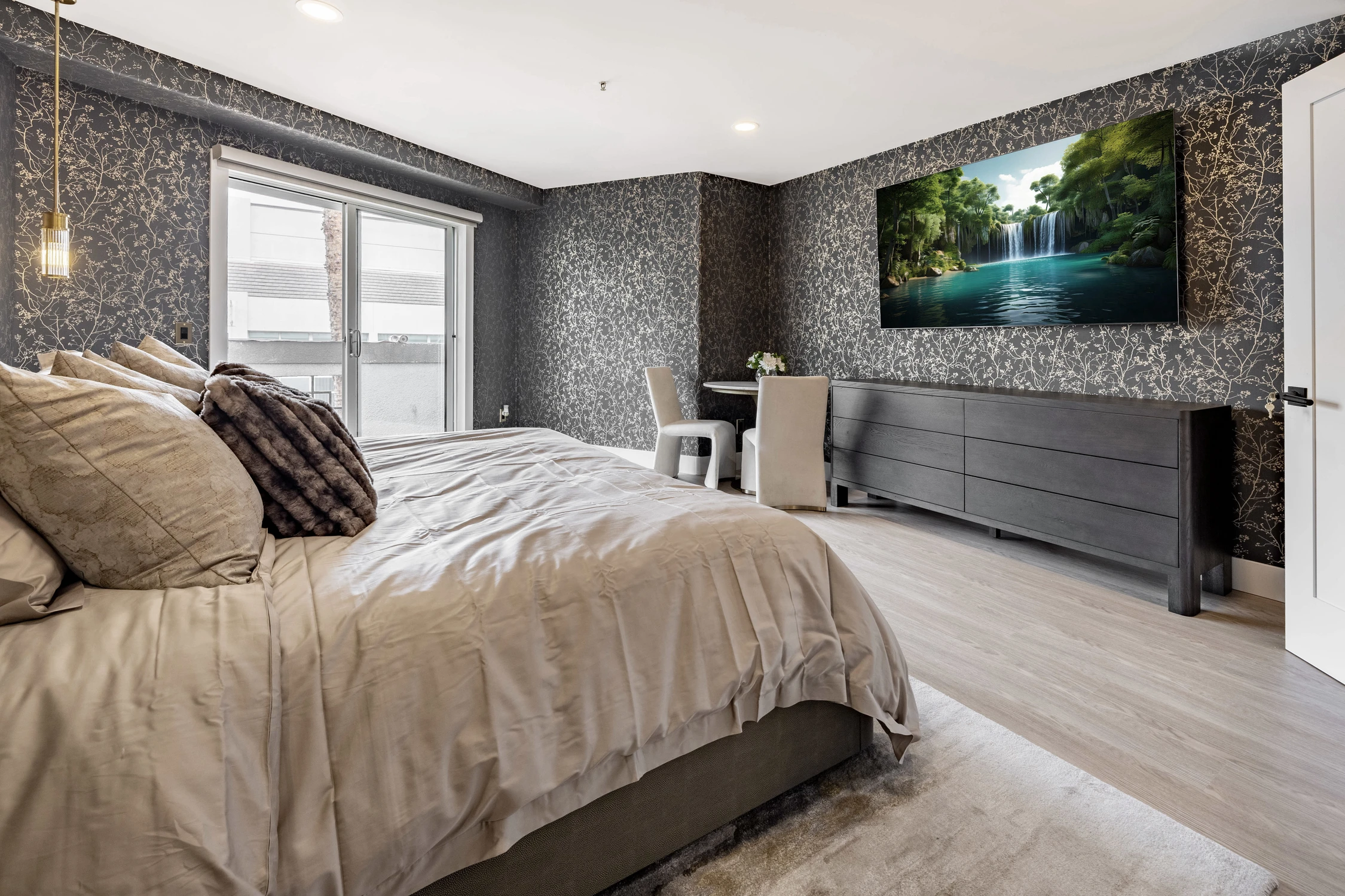 Bedroom with dark speckled wall and mounted television