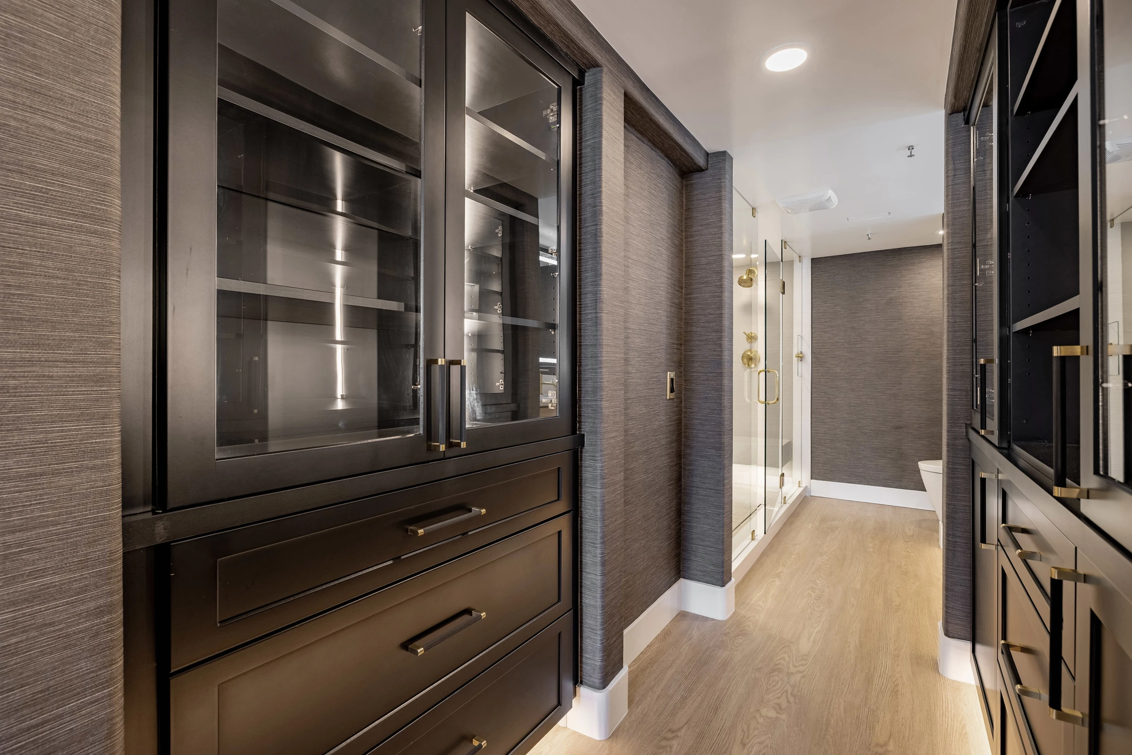 Walk-in closet with dark cabinetry and open shelves
