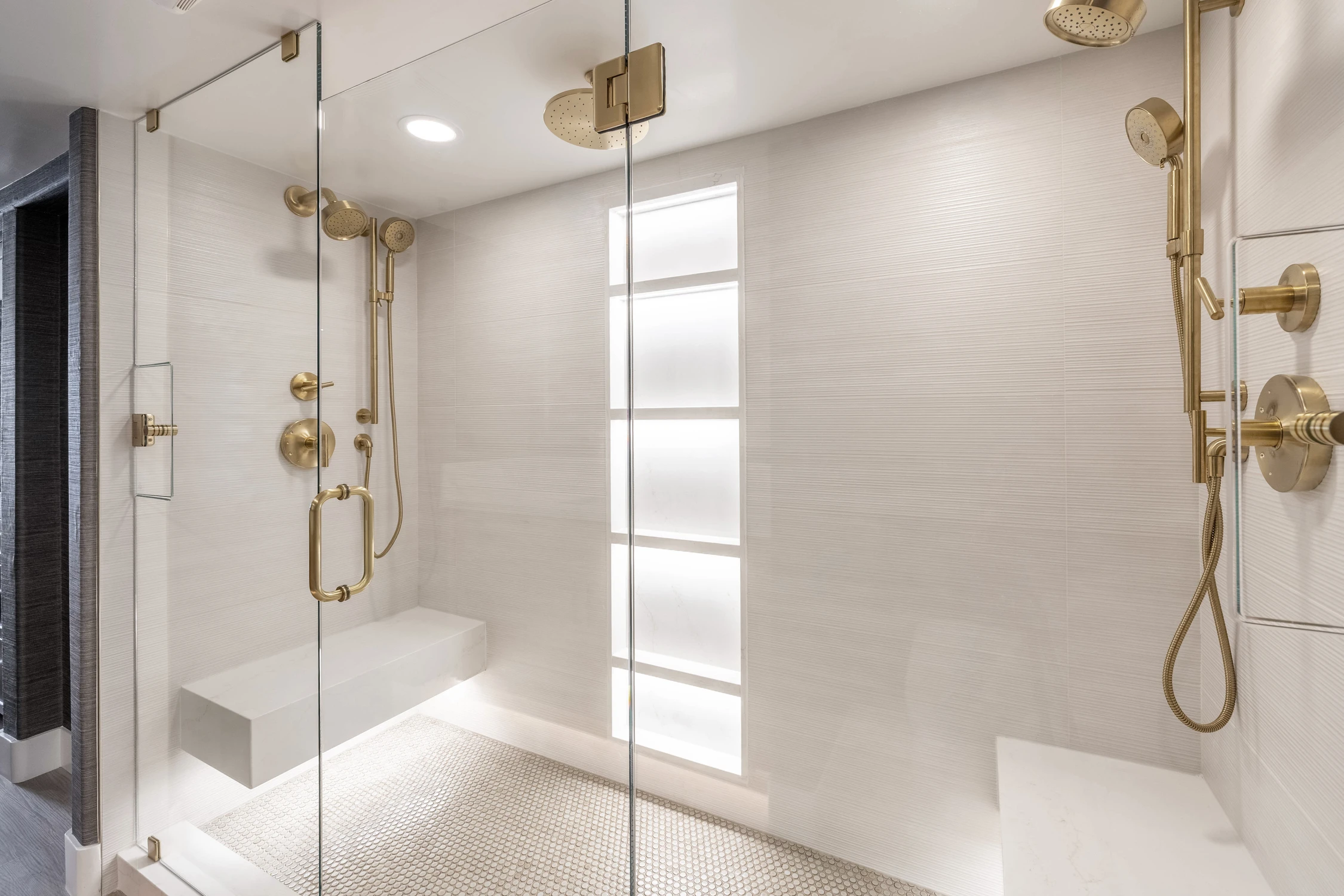 Walk-in shower with white tile and gold rain shower