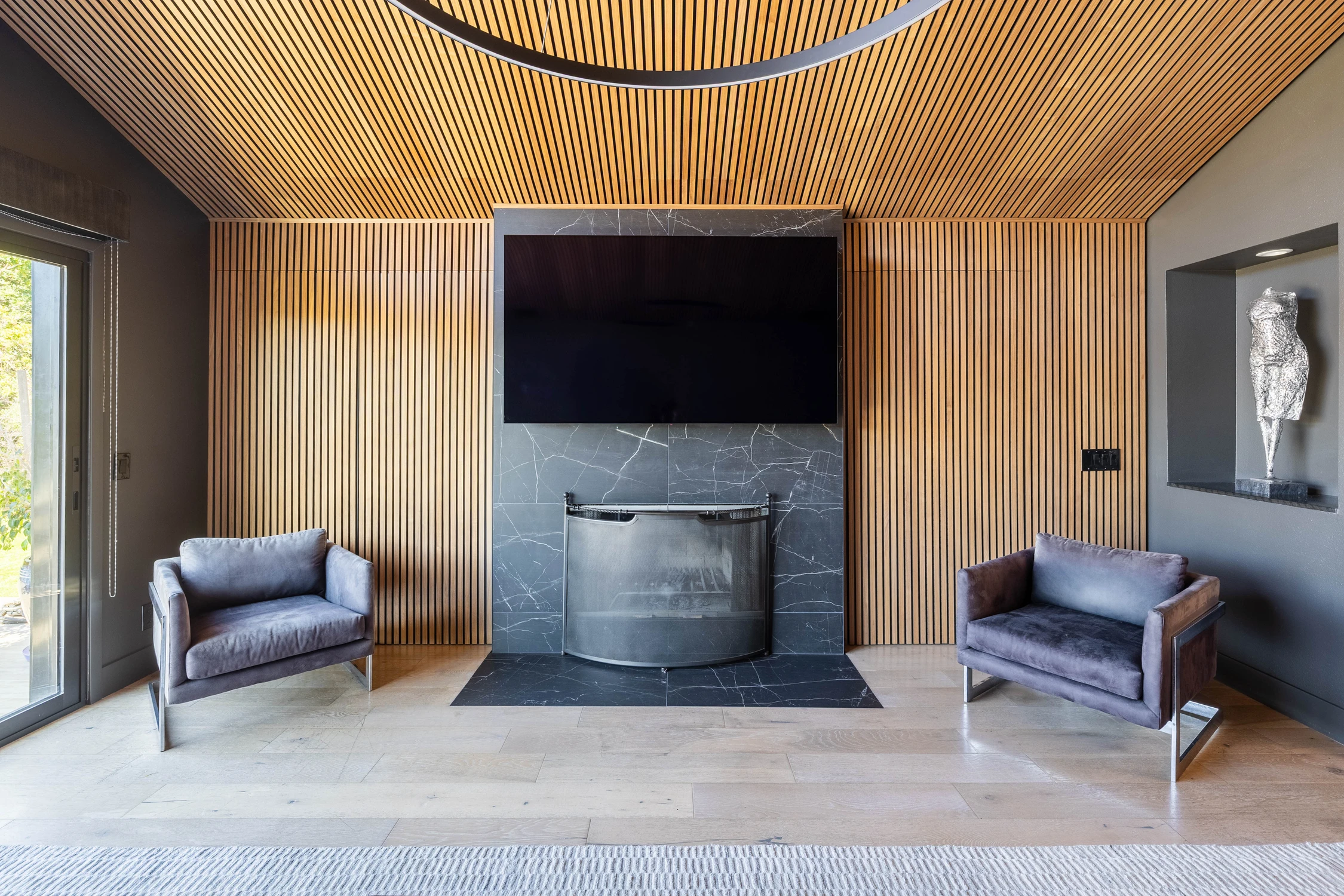 Family room fireplace wall framed by vertical wood slats