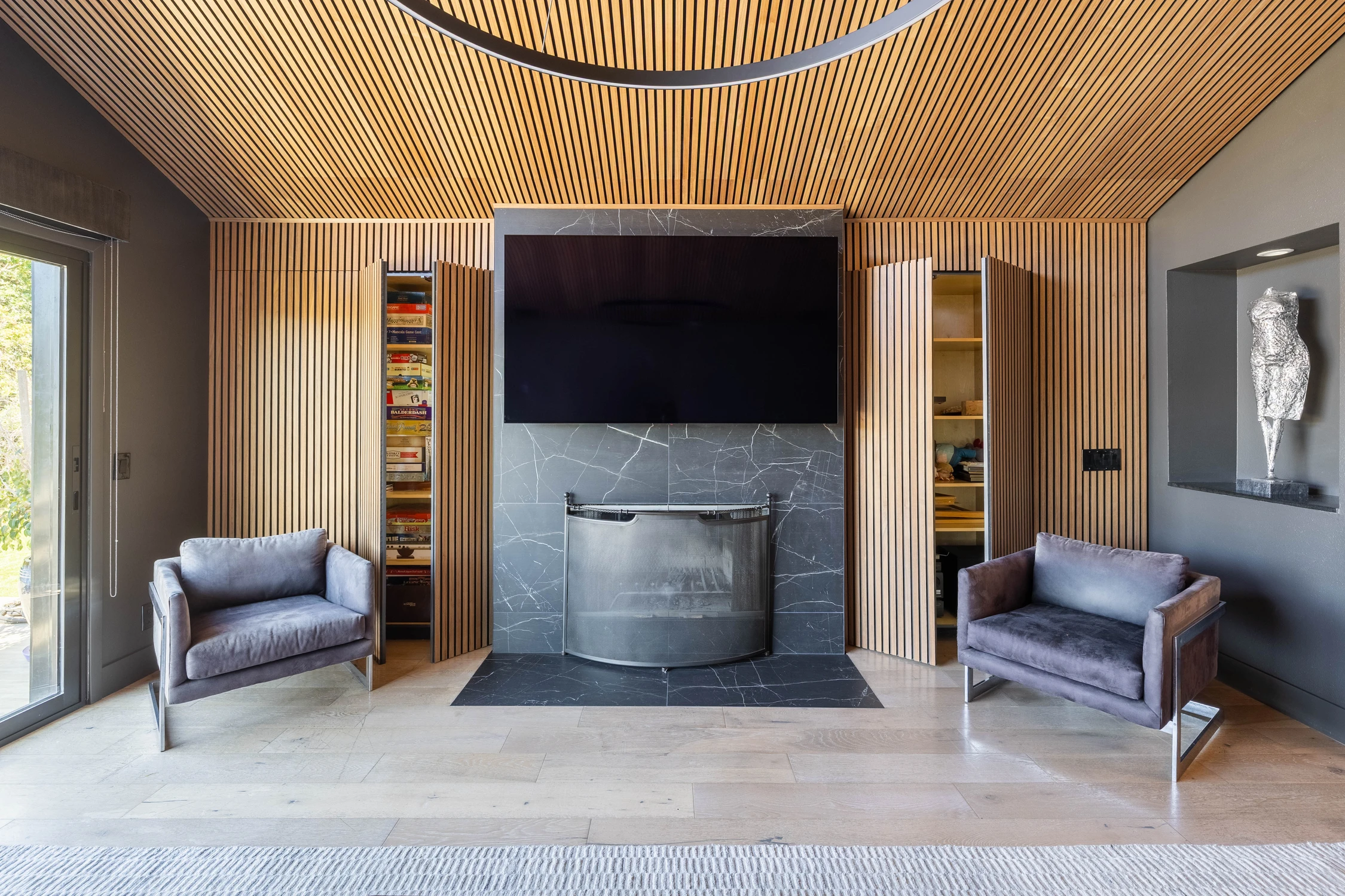 Family room seating arranged around a dark stone fireplace