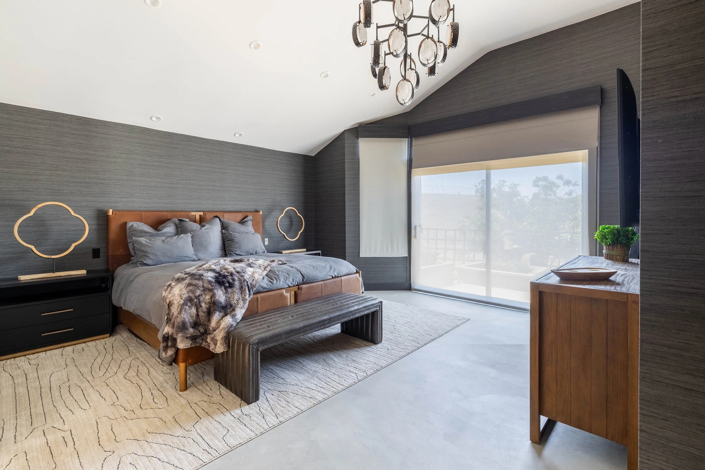 Bedroom with gray upholstered bed and dark paneled feature wall