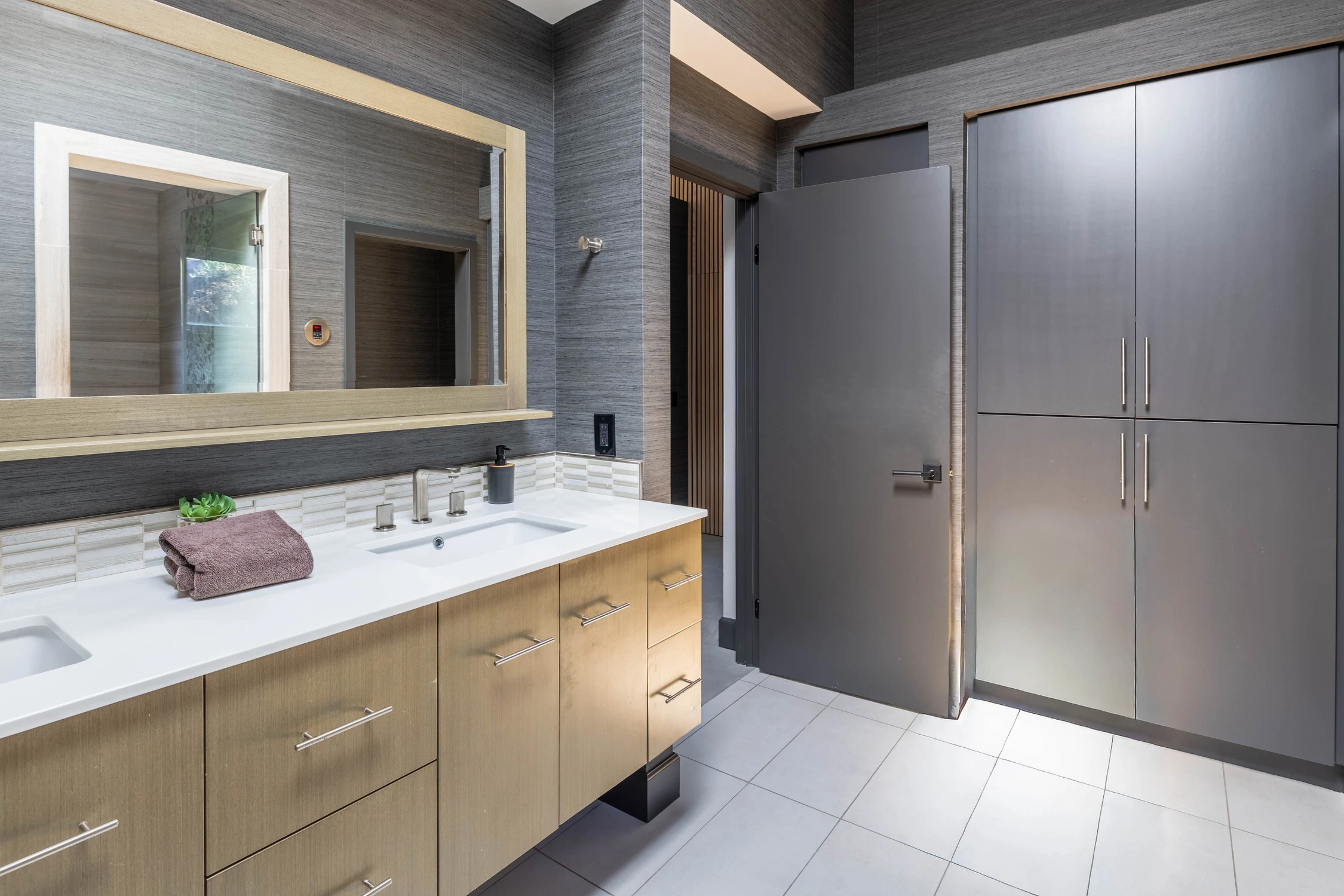 Large bathroom vanity with a wide mirror and dark cabinets