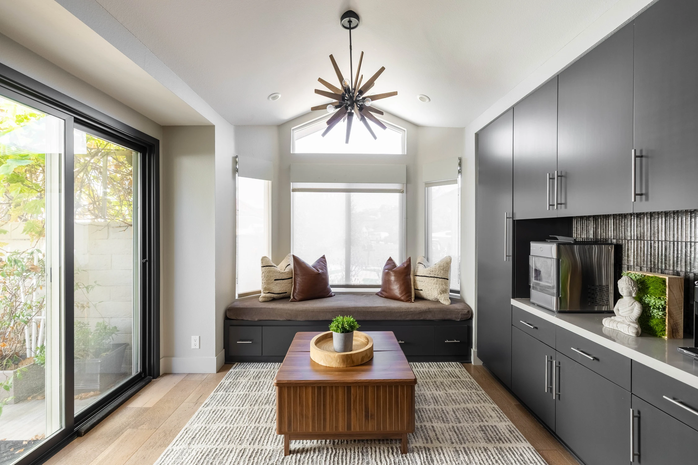 Window seat beside dark cabinetry and glass door