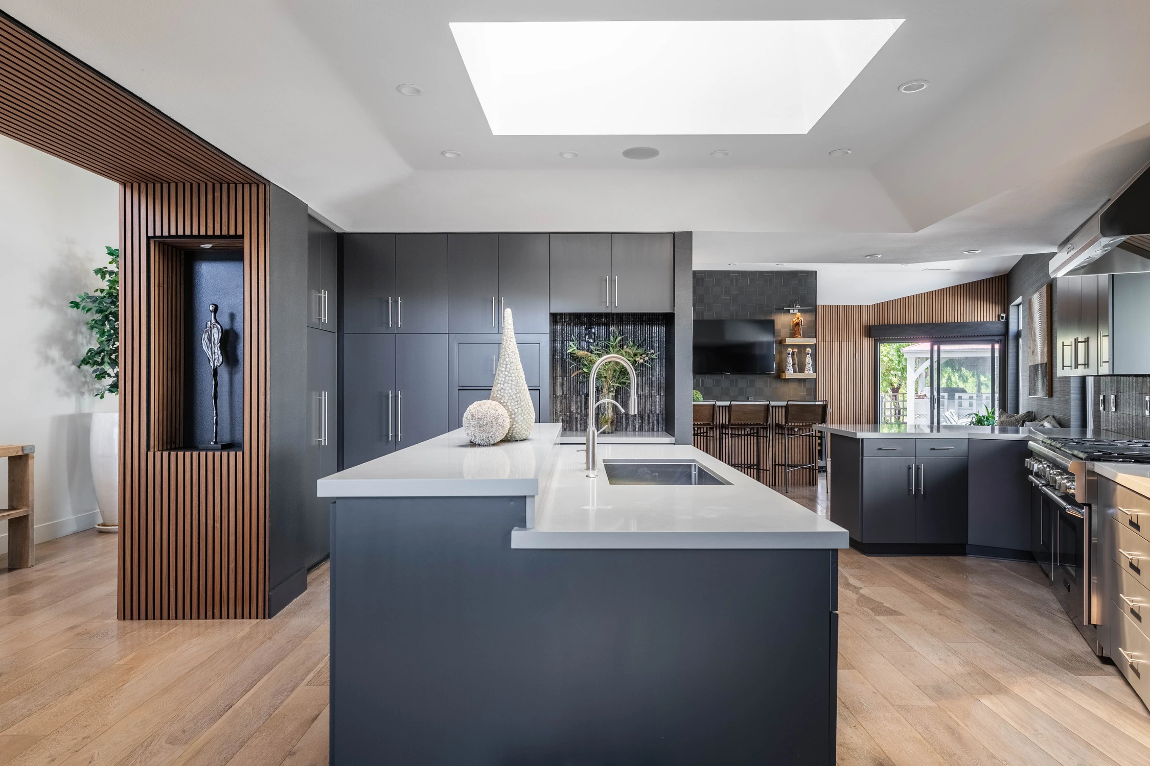 Kitchen seating area beside tall dark cabinetry and glass doors