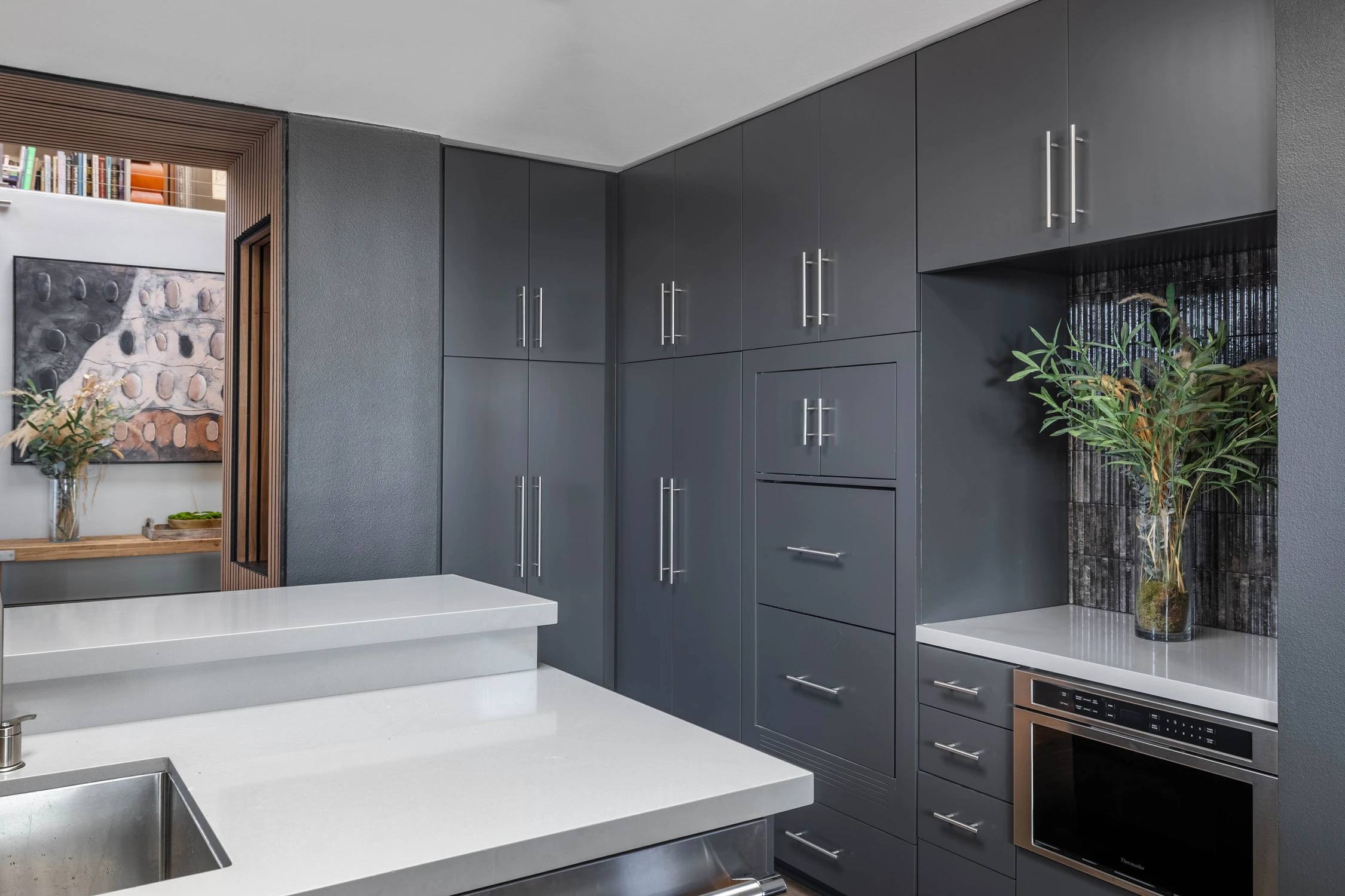 Kitchen island beneath recessed ceiling lights and wood accents