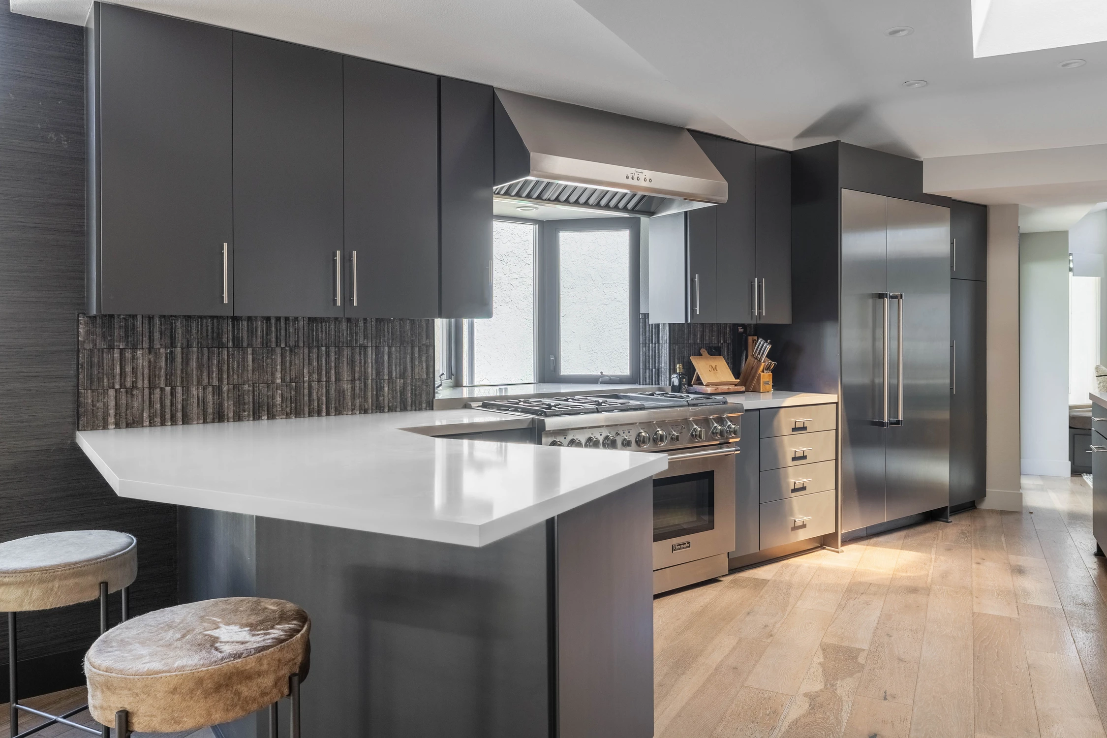 Kitchen sink with garden view and dark backsplash tile