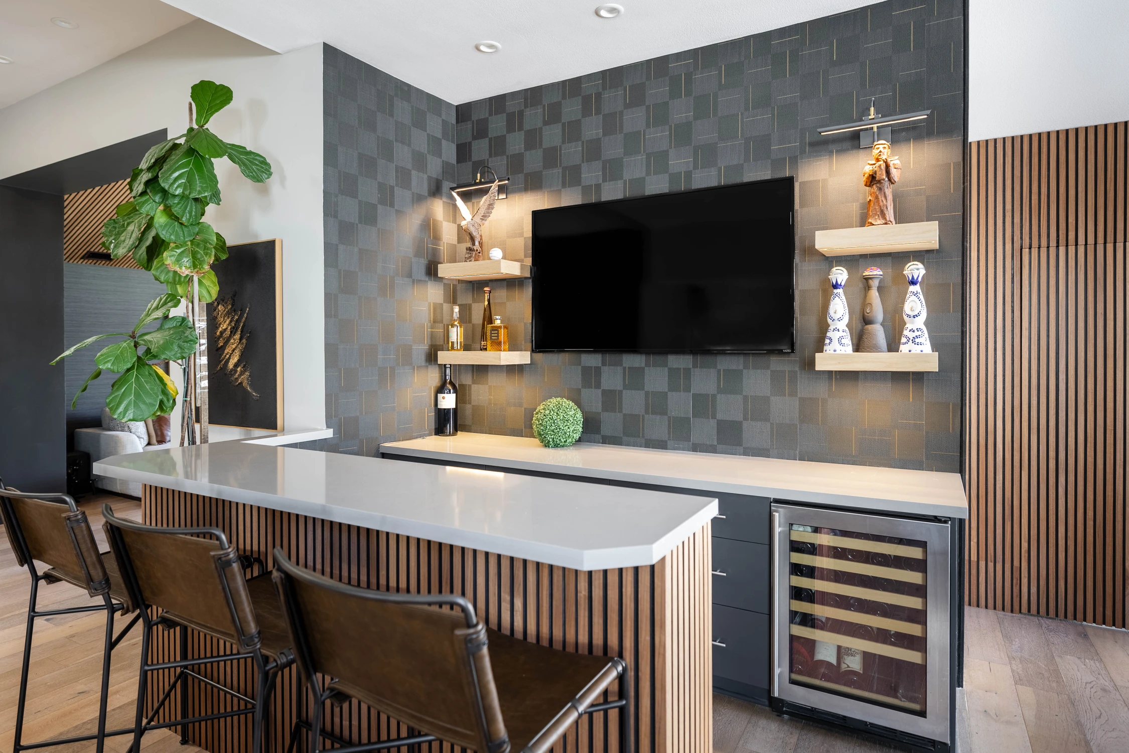 Wood-and-black bar cabinetry beneath a patterned tile wall