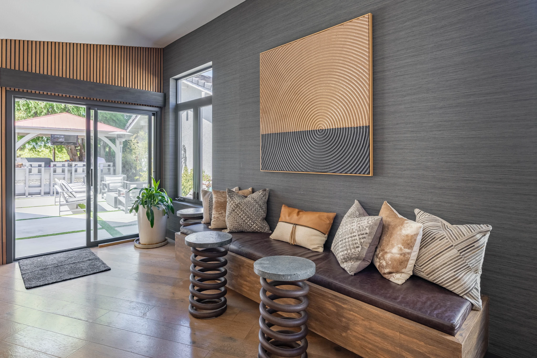 Living room seating nook with dark wall panel and wide windows