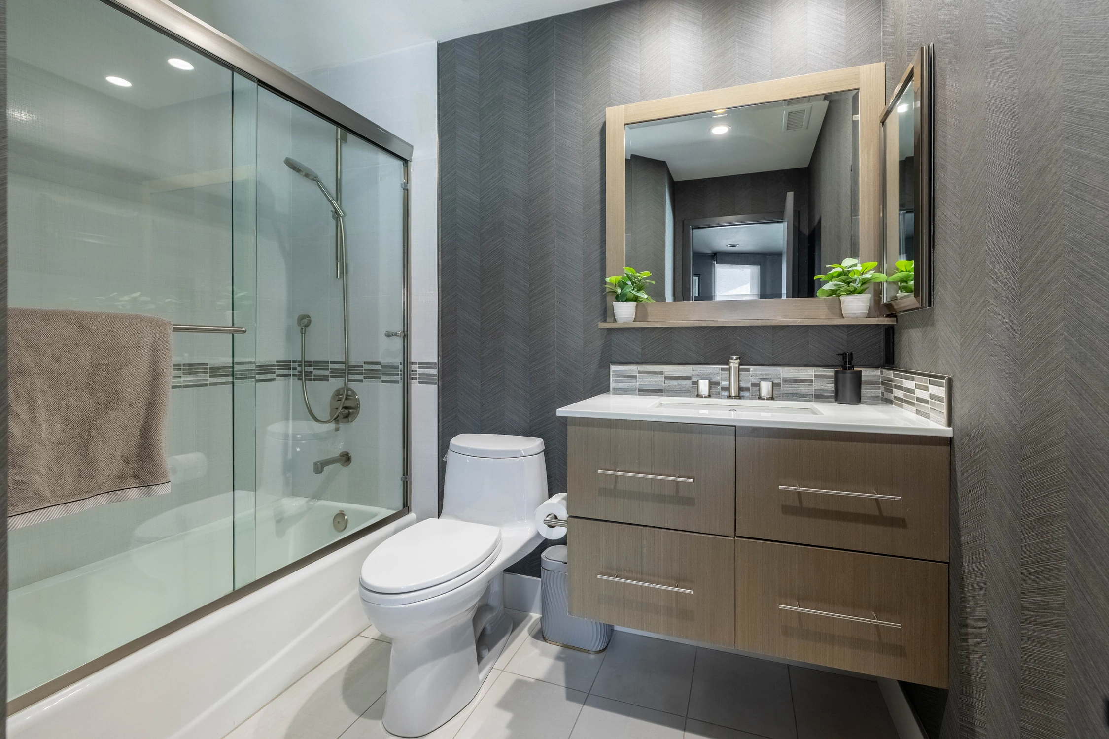 Bathroom with glass shower enclosure and wall-mounted toilet