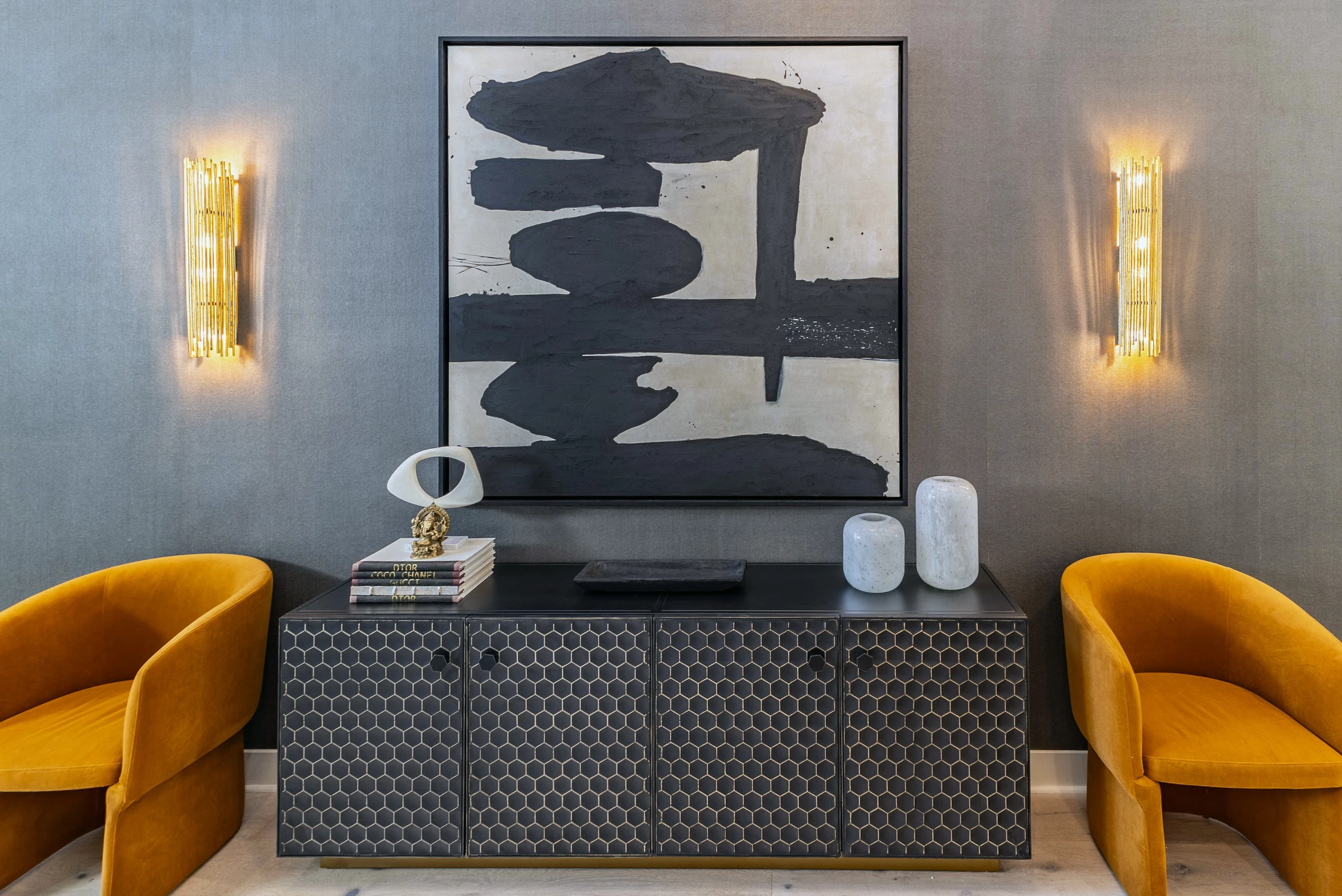 Entry console beneath abstract art with mustard velvet chairs