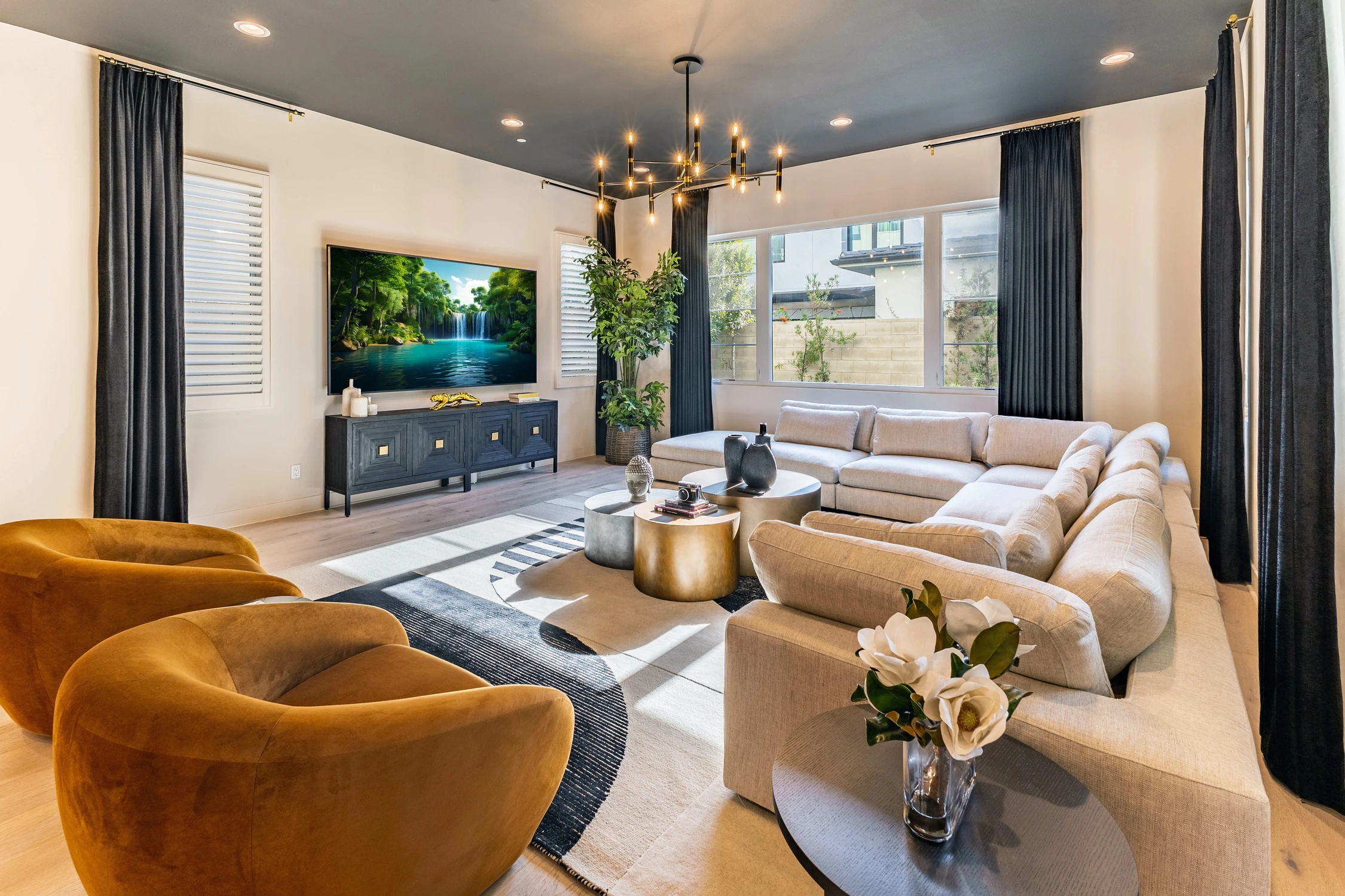 Living room with caramel chairs, light sectional, and black ceiling