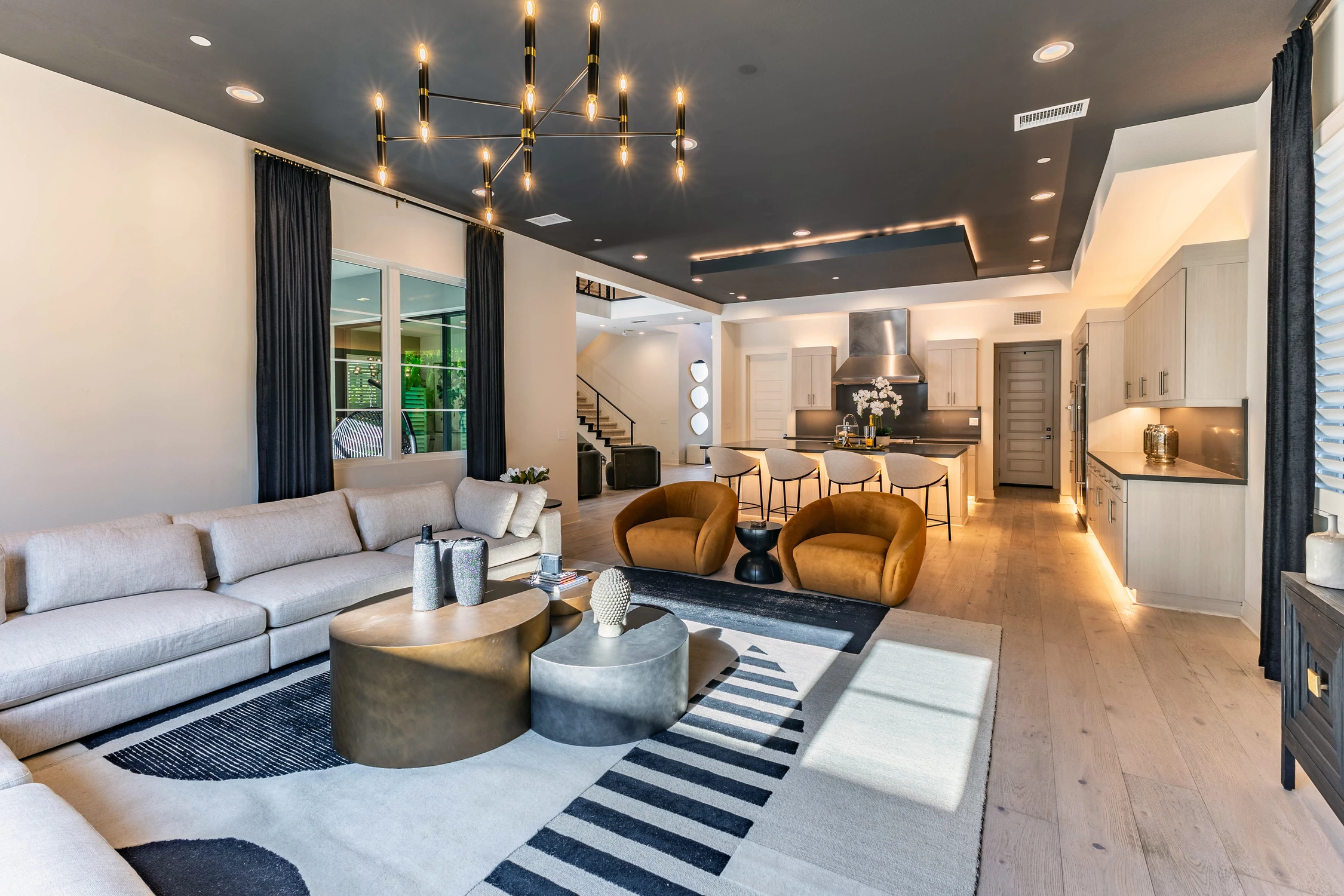 Living room with caramel chairs, sectional, and black media console
