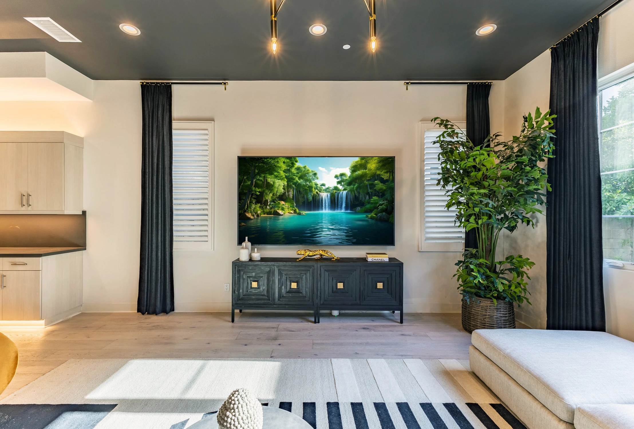 Living room TV area with black media console and dark curtains
