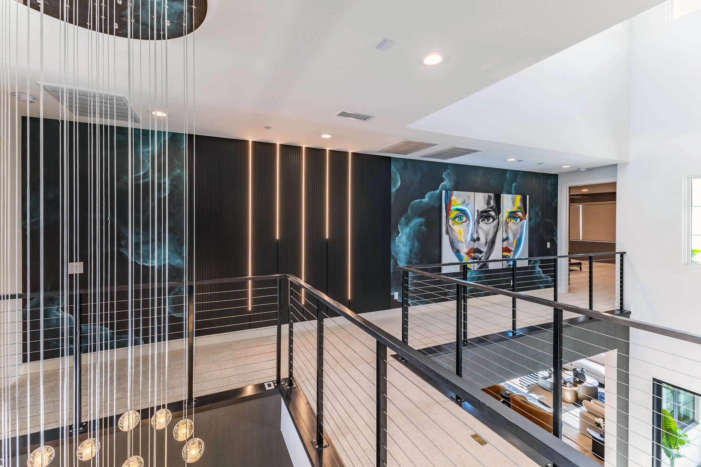 Upper landing with black railings, wood wall panels, and pendant lights