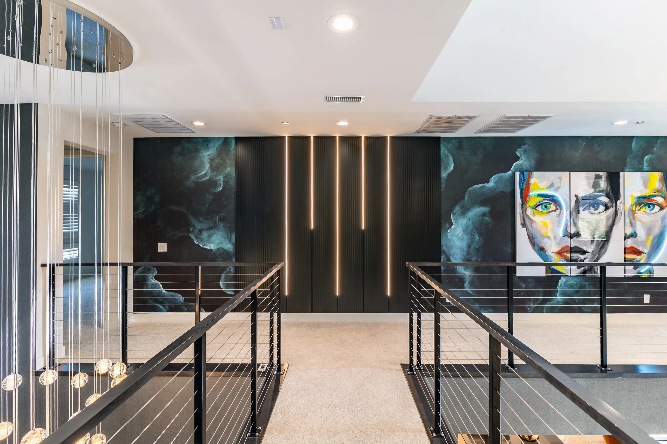 Upper landing with black railings, smoky mural-style wallpaper, and illuminated wood panels