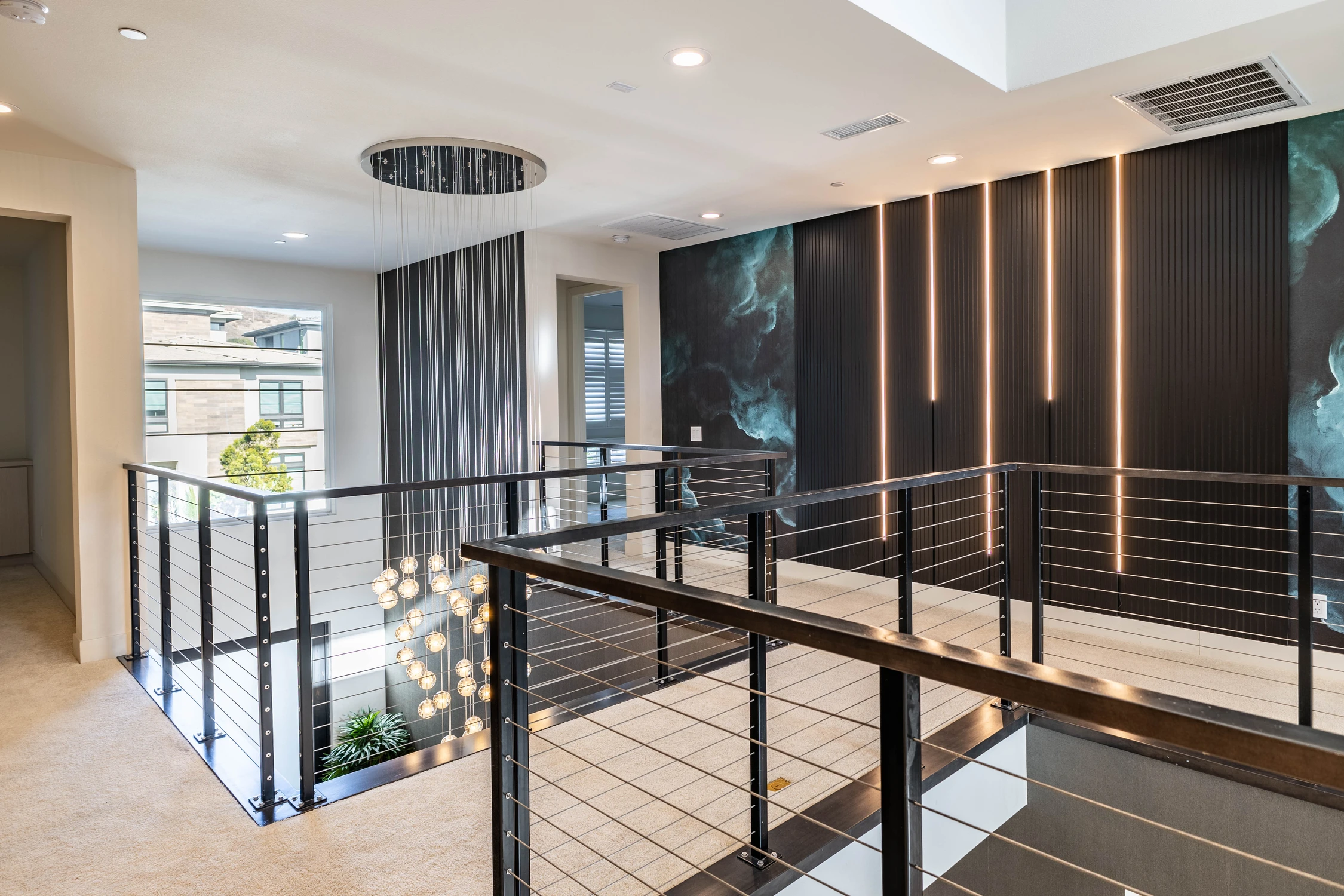 Upper landing with illuminated wood wall panels and chandelier