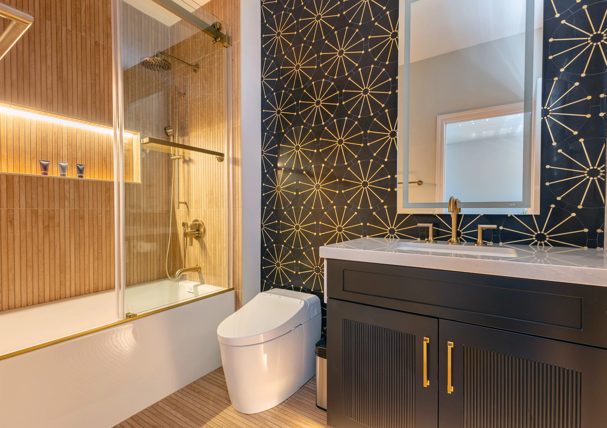 Bathroom with black vanity, patterned wall tile, and tub-shower