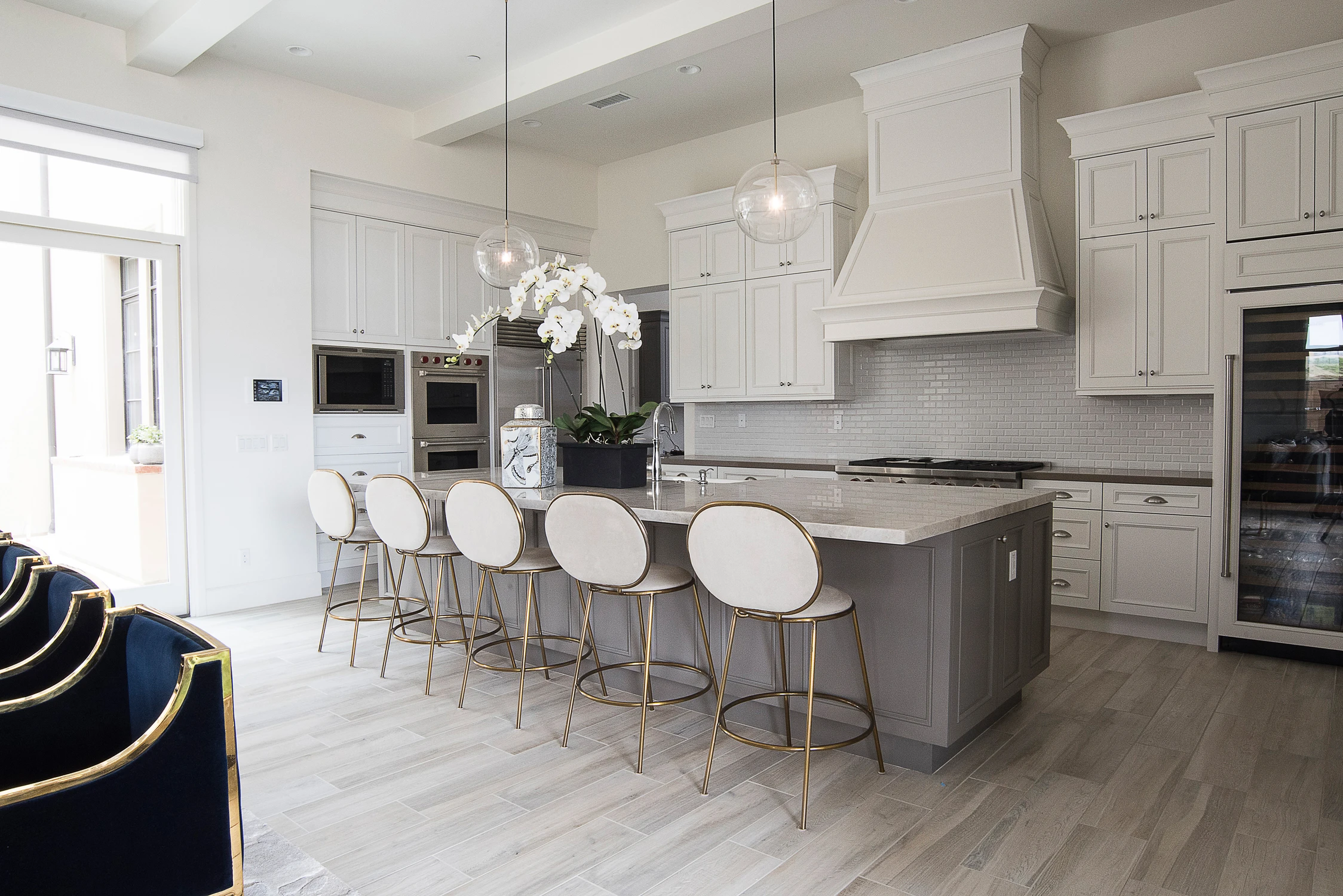 White kitchen with gray island and navy dining chairs