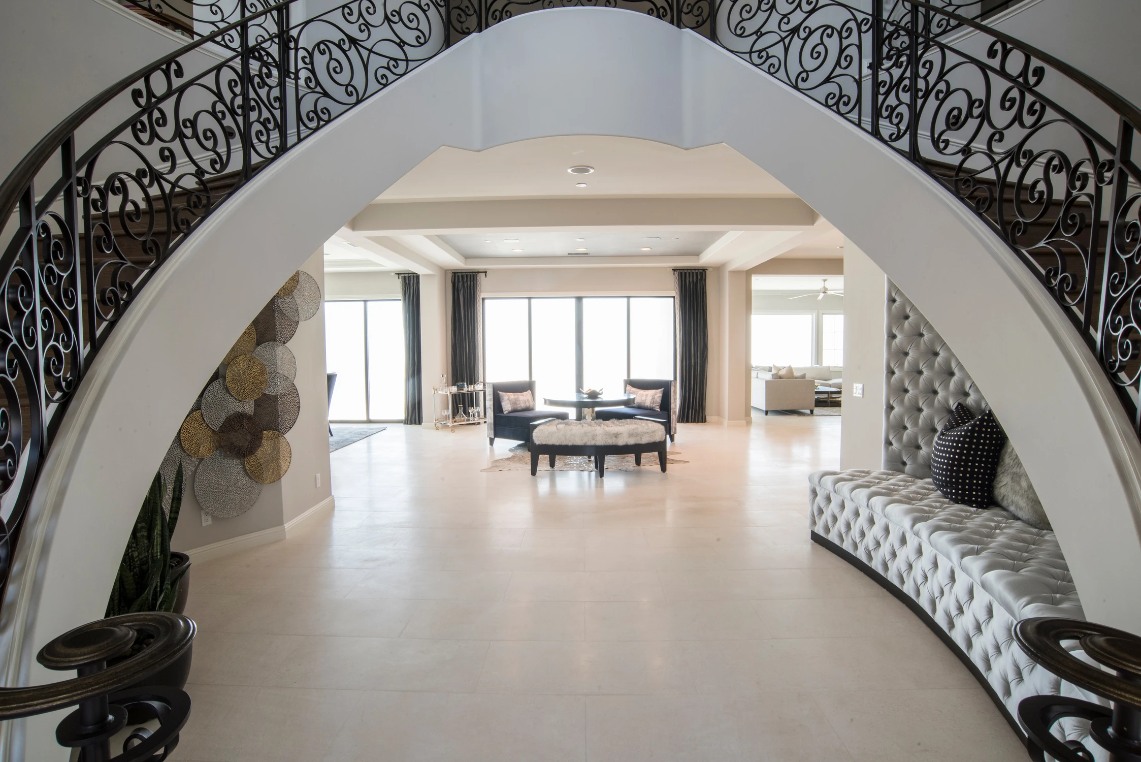 Arched foyer opening with tufted bench and view into living room