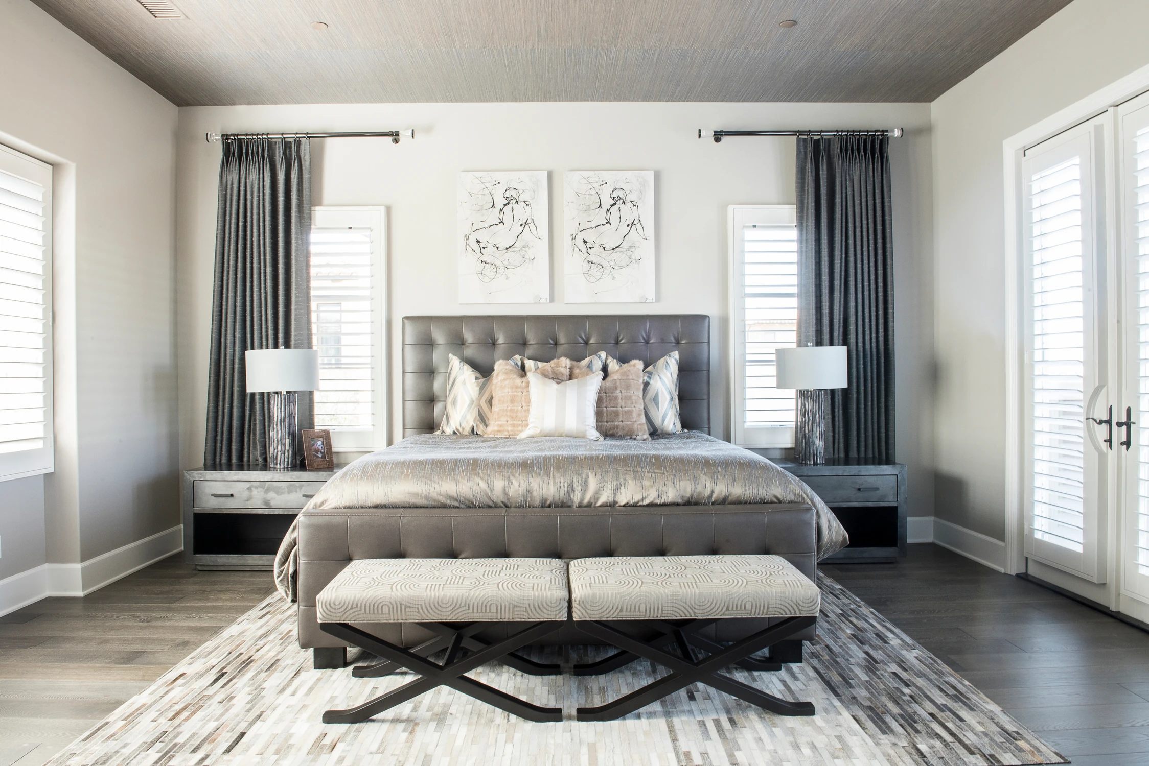 Bedroom close view with gray upholstered bed and dark drapery