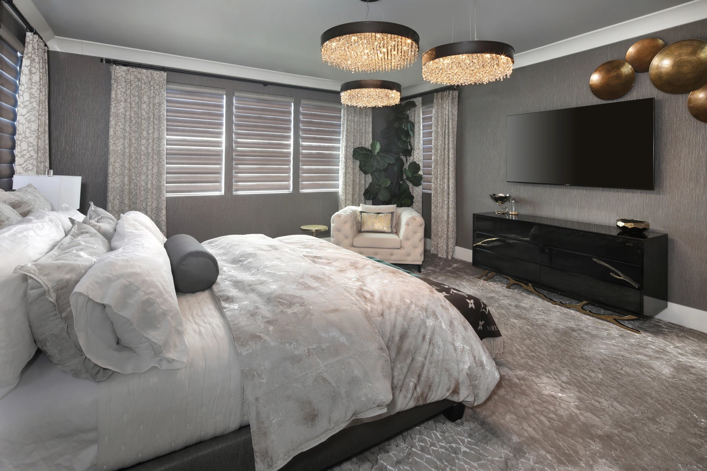 Bedroom with layered gray bedding and upholstered bench