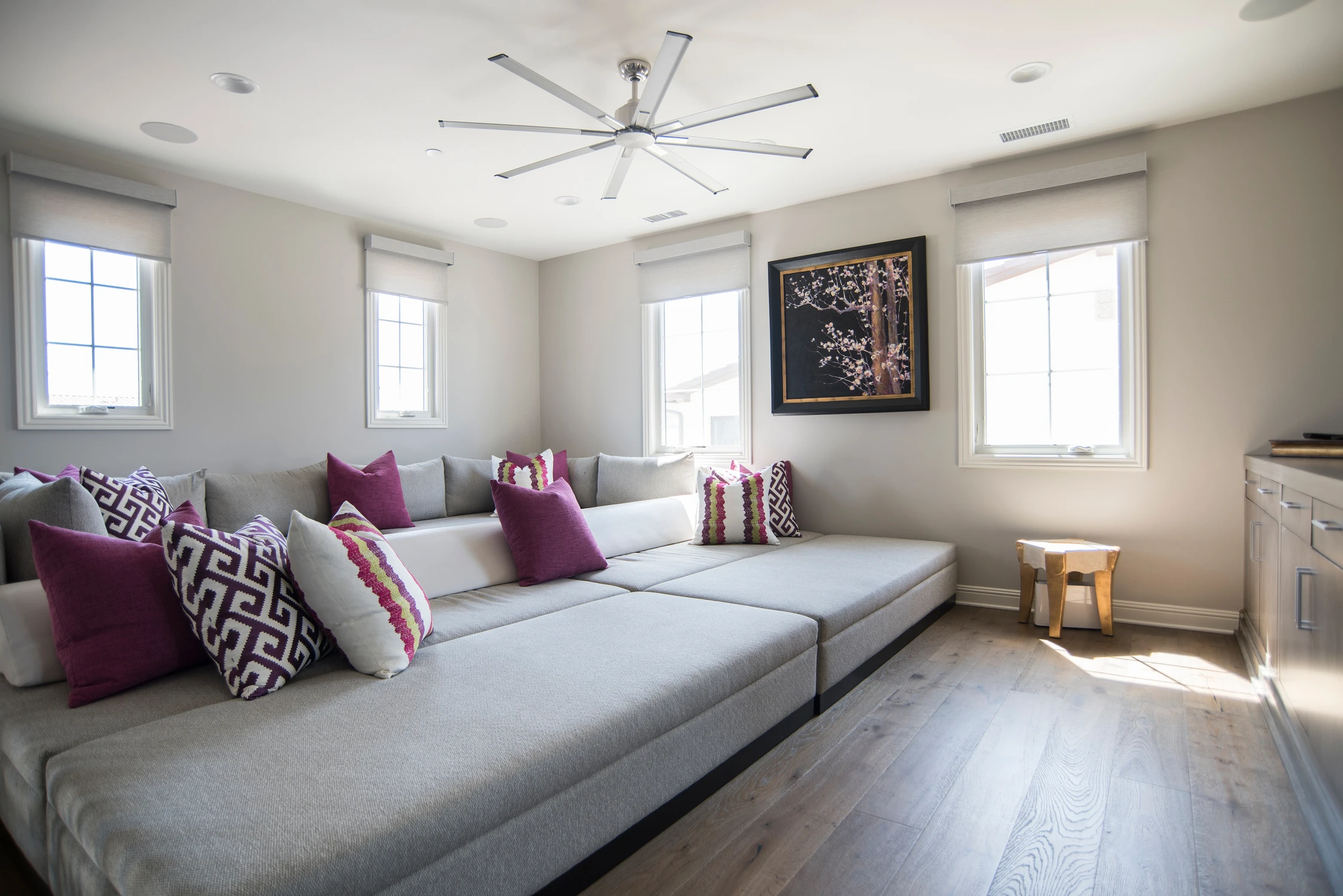 Upper sitting room with pale sectional and magenta accent pillows