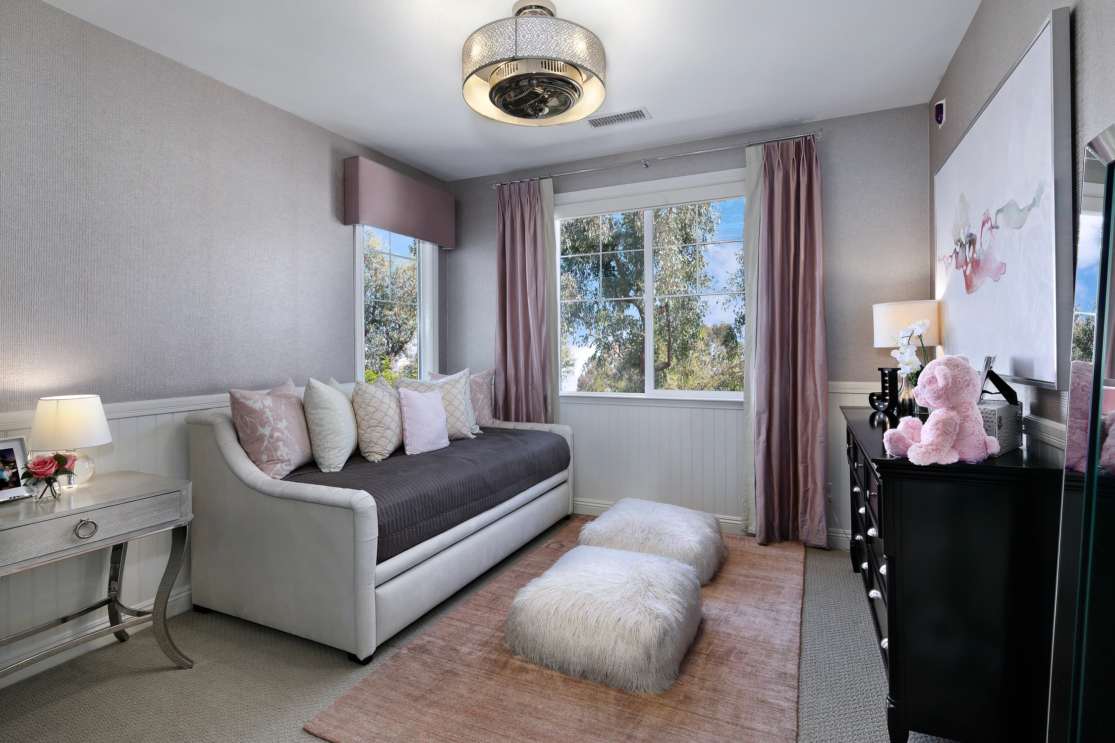 Bedroom seating area with gray chaise and blush pink accents
