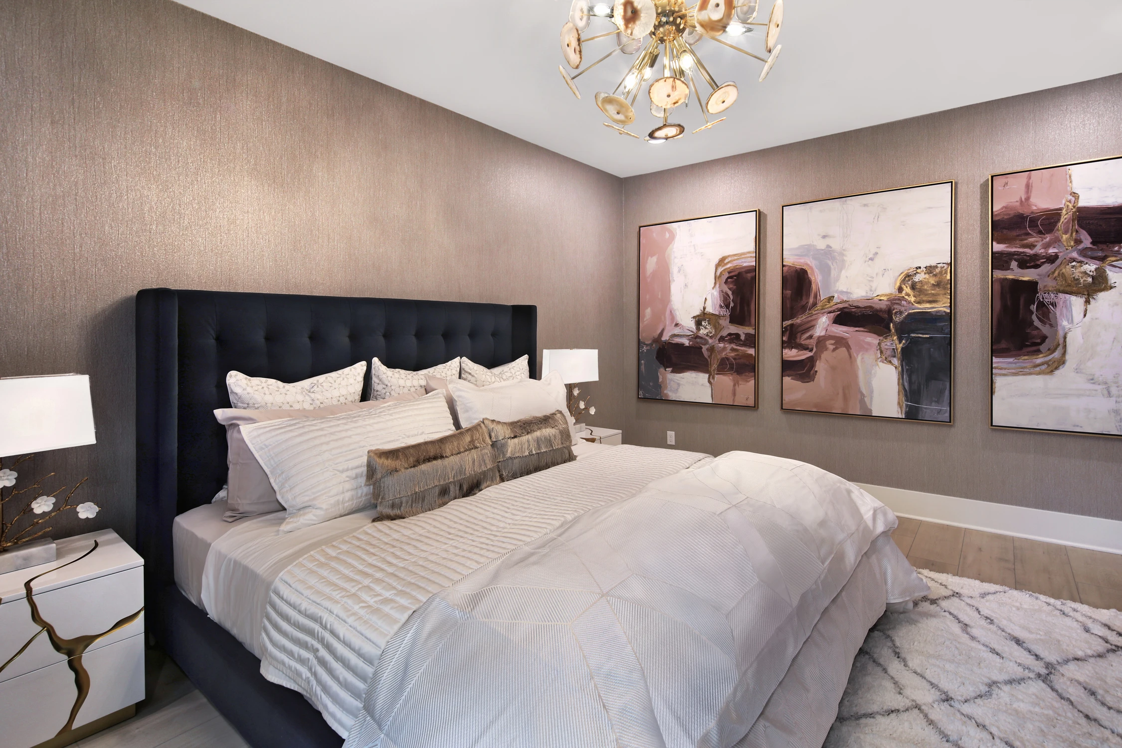 Bedroom with navy upholstered bed and framed wall art
