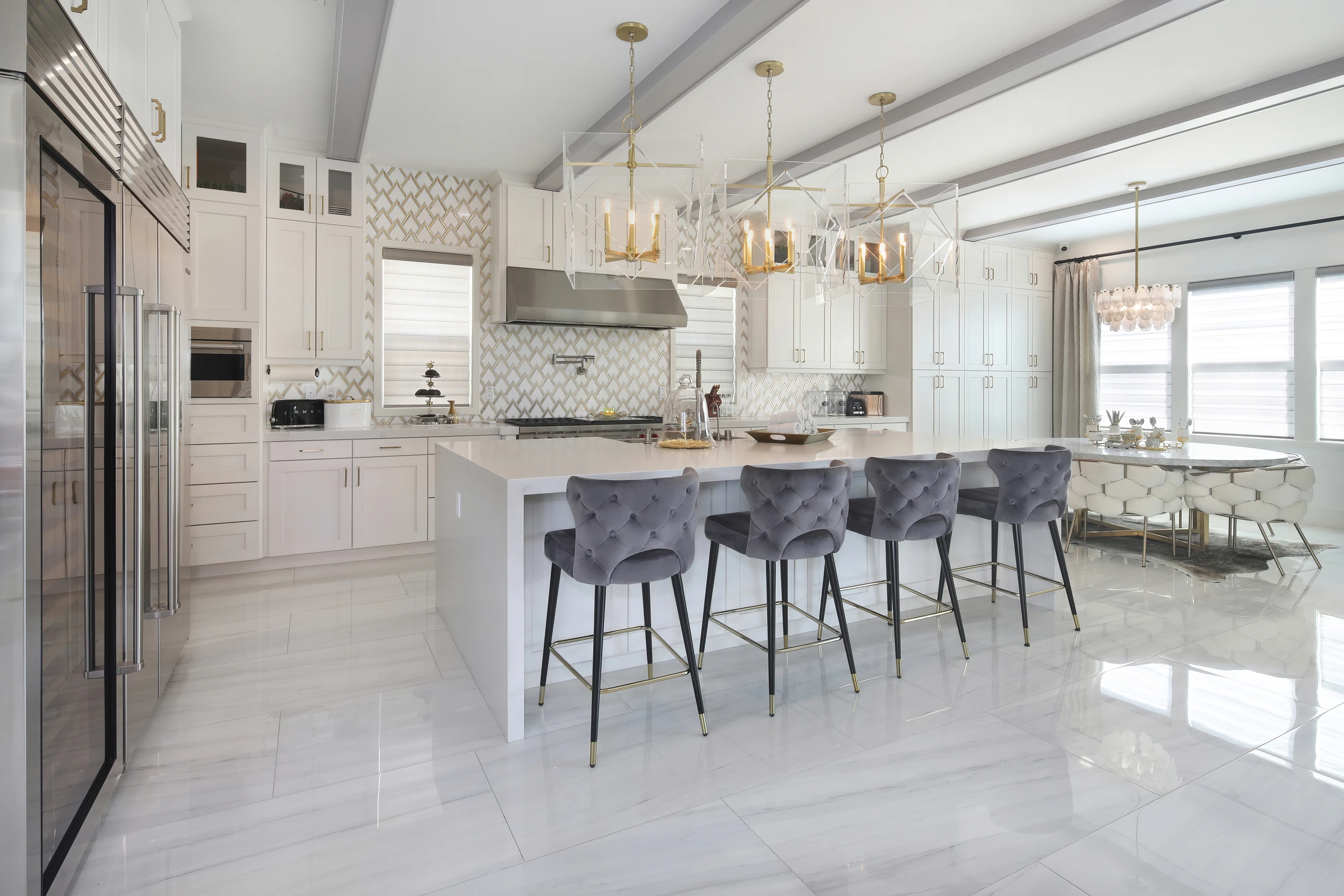 White kitchen with dark island and crystal chandelier