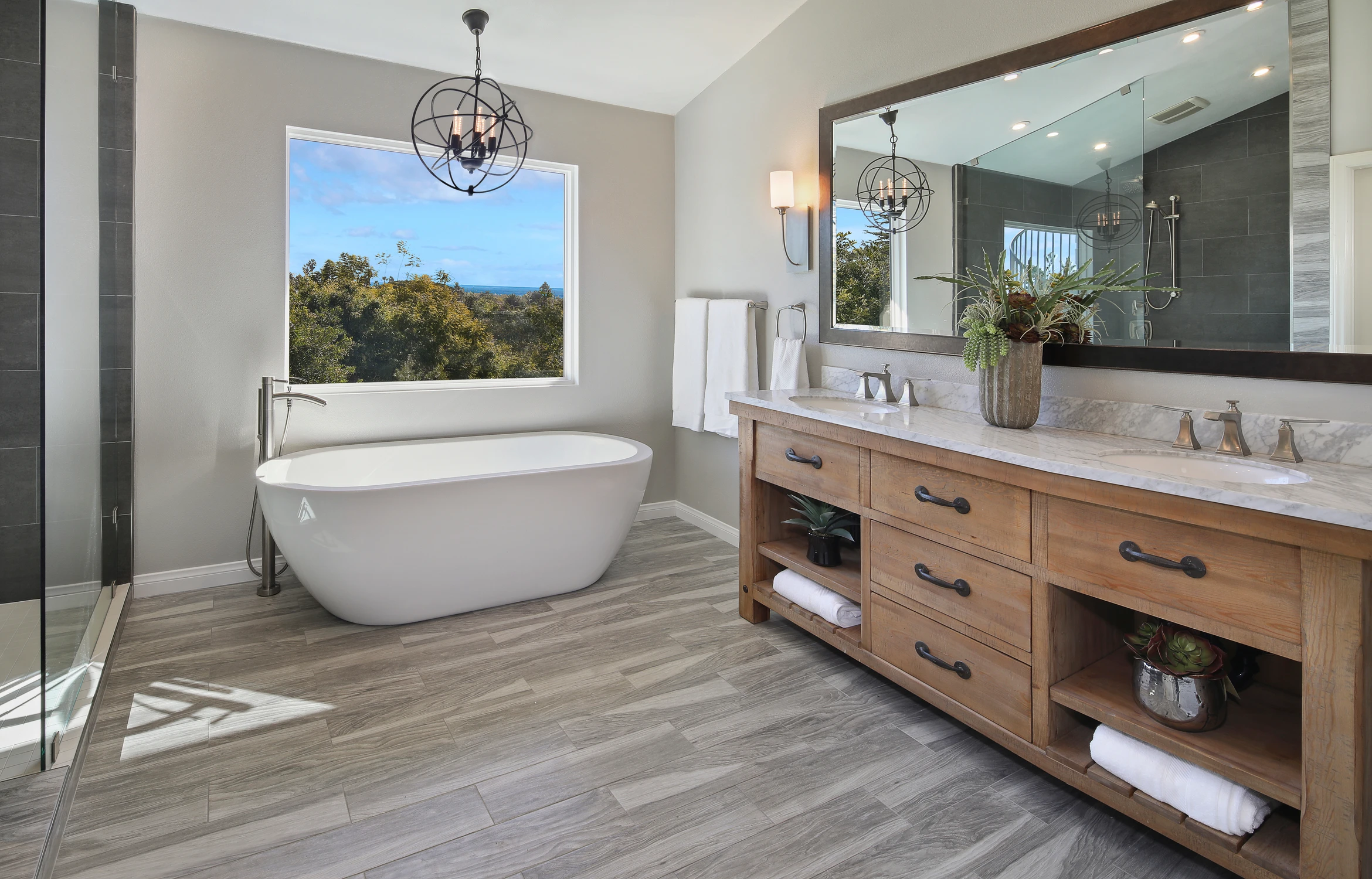 Master bathroom vanity with wood drawers, vessel sinks, and wide mirror